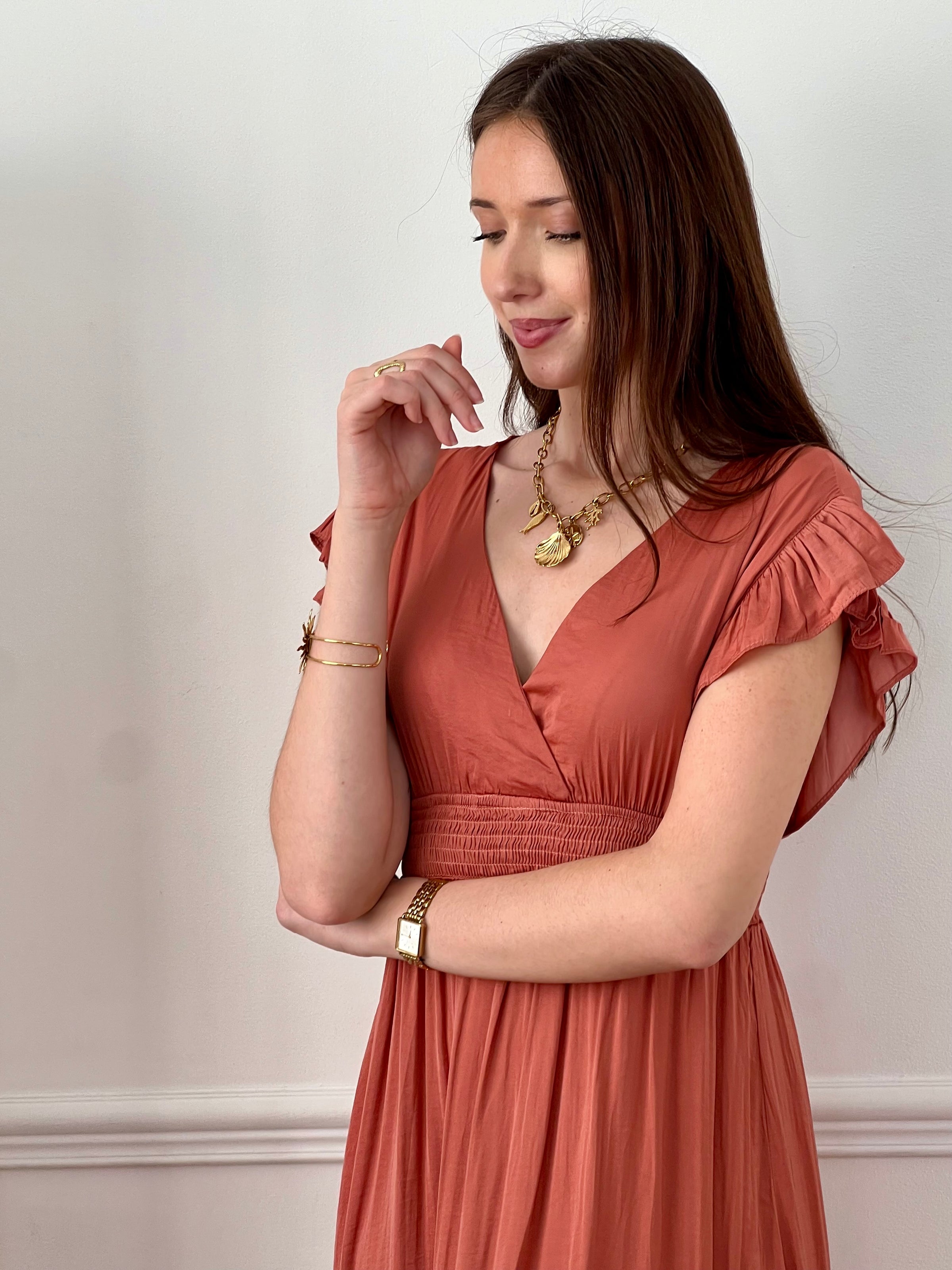 Craquez pour cette robe longue femme terracotta, élégante et féminine. Sans manches, elle se distingue par ses volants aux épaules et son col V plongeant qui sublime le décolleté. Son dos nu avec lien à nouer apporte une touche raffinée, tandis que sa taille élastique assure confort et maintien. Une pièce idéale pour un look chic et estival.