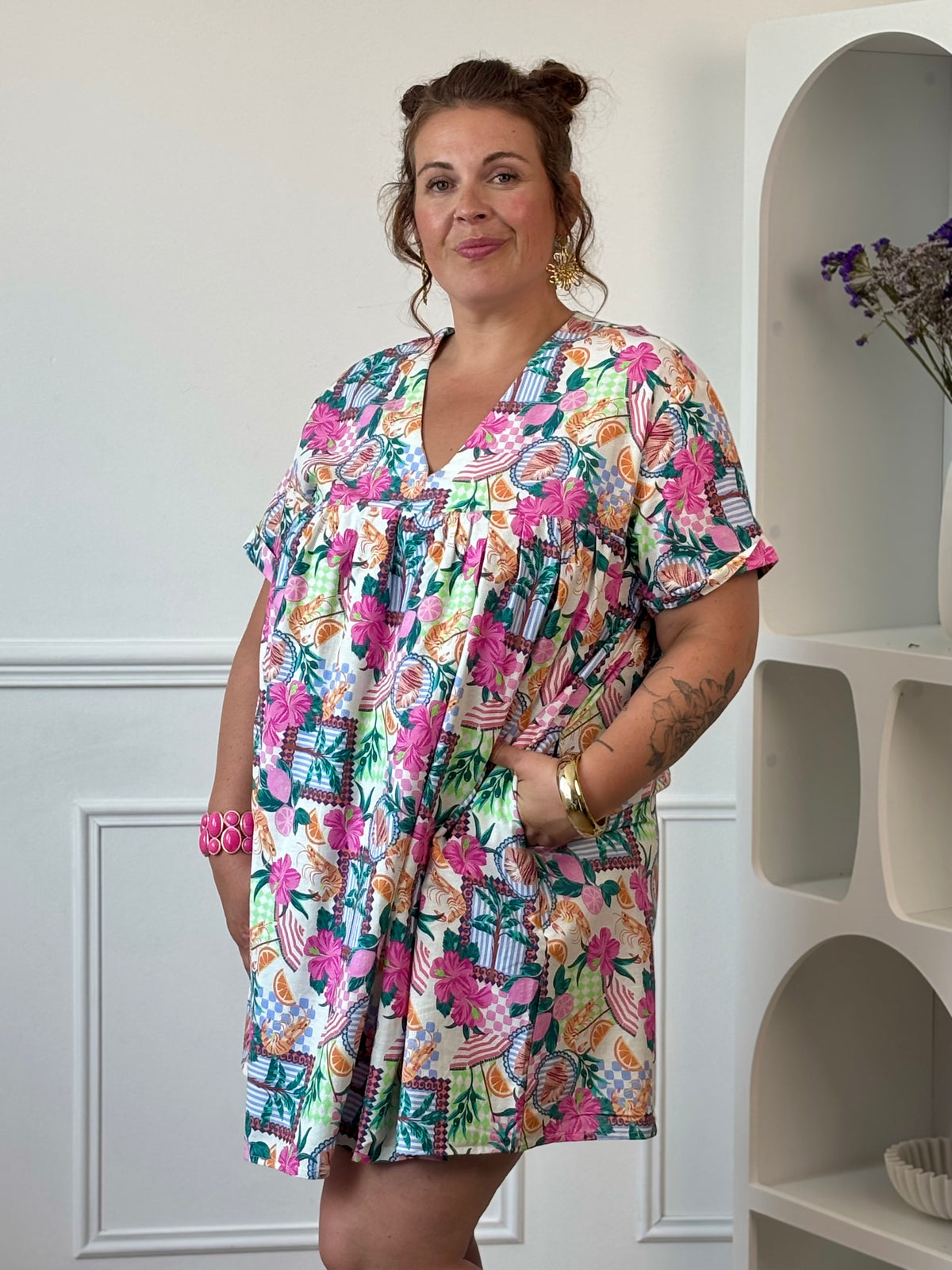 Apportez une touche de fraîcheur à votre dressing avec cette robe short grande taille femme. Son col V, ses manches courtes, son dos nu fermé par un bouton et sa taille élastiquée au dos offrent une coupe confortable et féminine. Ses poches latérales et son imprimé estival mêlant fleurs, coquillages, fruits et crevettes dans des tons écru, rose, vert, bleu et orange en font une pièce originale et tendance.