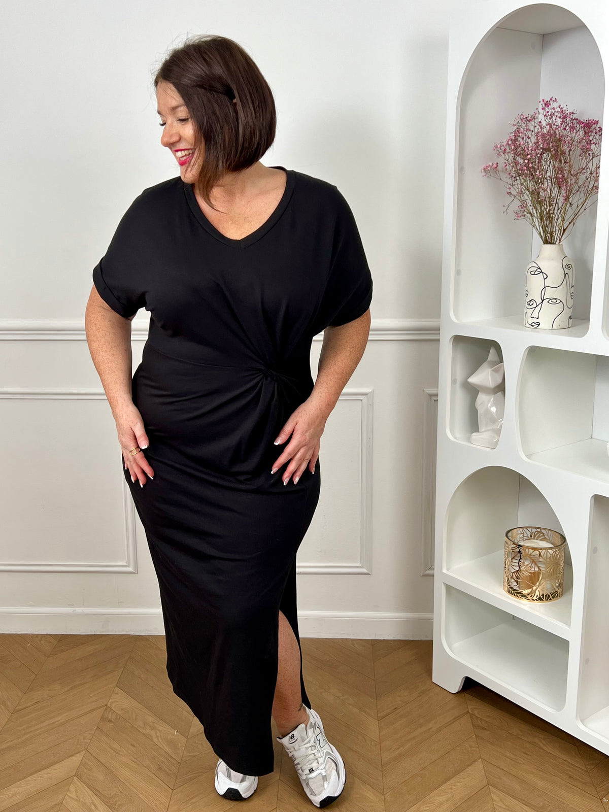 Robe en coton grande taille femme, idéale pour un look à la fois confortable et élégant. Avec ses manches courtes à revers, son col V et sa coupe ample, elle met en valeur toutes les silhouettes. Sa fente sur le bas et son drapé noué sur le côté apportent une touche féminine et moderne. Facile à porter au quotidien, cette robe noire est un indispensable du dressing.