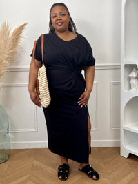 Robe en coton grande taille femme, idéale pour un look à la fois confortable et élégant. Avec ses manches courtes à revers, son col V et sa coupe ample, elle met en valeur toutes les silhouettes. Sa fente sur le bas et son drapé noué sur le côté apportent une touche féminine et moderne. Facile à porter au quotidien, cette robe noire est un indispensable du dressing.