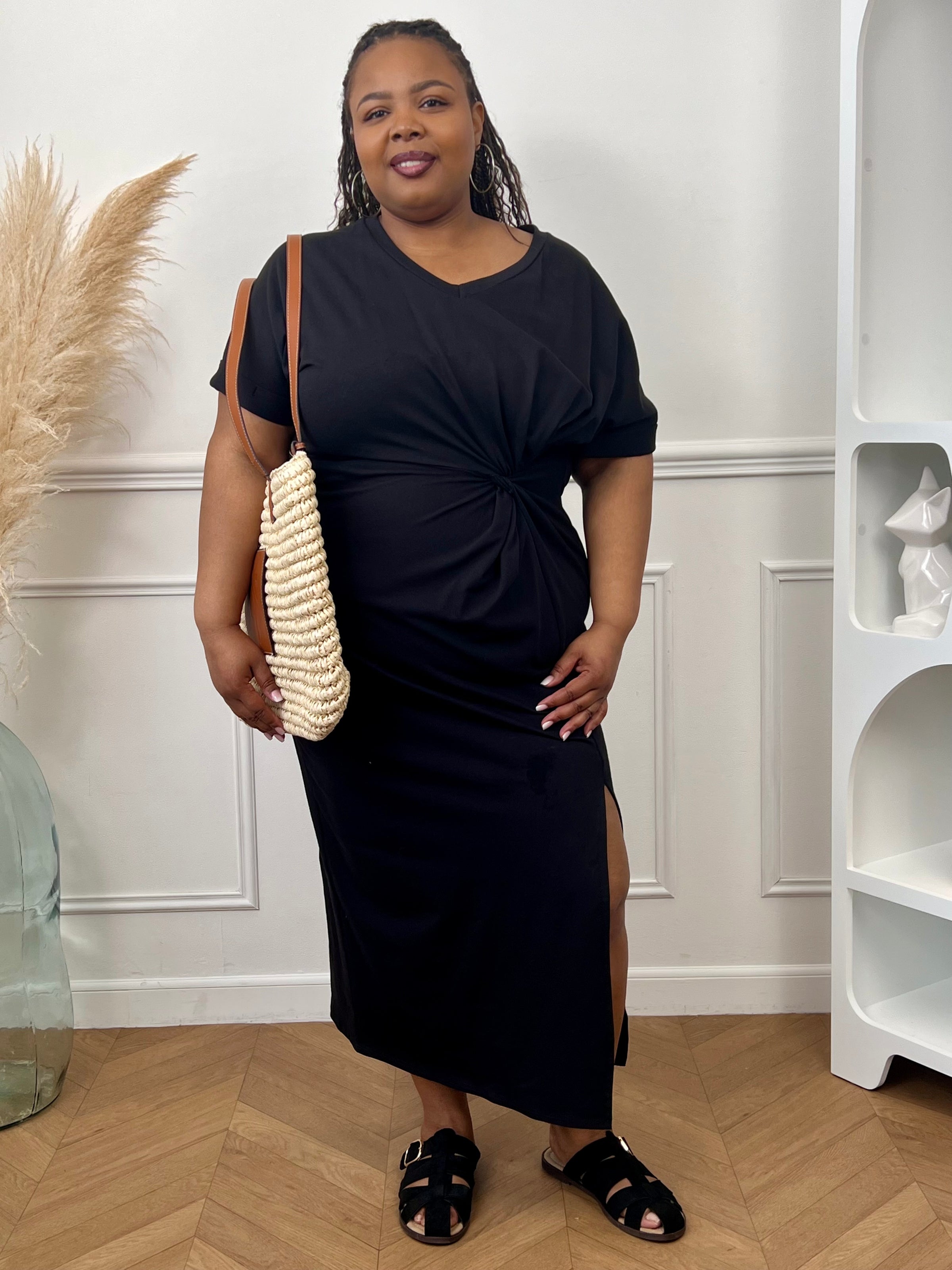 Robe en coton grande taille femme, idéale pour un look à la fois confortable et élégant. Avec ses manches courtes à revers, son col V et sa coupe ample, elle met en valeur toutes les silhouettes. Sa fente sur le bas et son drapé noué sur le côté apportent une touche féminine et moderne. Facile à porter au quotidien, cette robe noire est un indispensable du dressing.