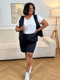 Adoptez ce short noir grande taille femme, à la fois confortable et facile à porter. Sa taille élastiquée assure un maintien optimal, complétée par une fermeture bouton et zip éclair. Sans passants, il offre une coupe épurée et dispose de deux poches à l’avant pratiques pour le quotidien.