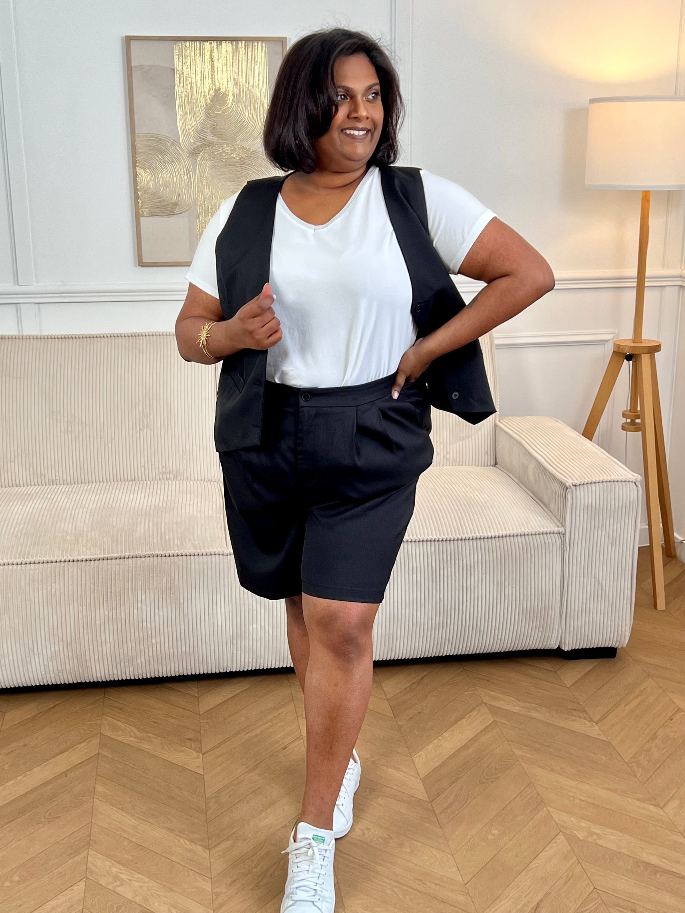 Adoptez ce short noir grande taille femme, à la fois confortable et facile à porter. Sa taille élastiquée assure un maintien optimal, complétée par une fermeture bouton et zip éclair. Sans passants, il offre une coupe épurée et dispose de deux poches à l’avant pratiques pour le quotidien.