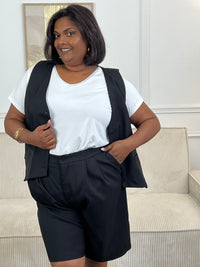 Adoptez ce short noir grande taille femme, à la fois confortable et facile à porter. Sa taille élastiquée assure un maintien optimal, complétée par une fermeture bouton et zip éclair. Sans passants, il offre une coupe épurée et dispose de deux poches à l’avant pratiques pour le quotidien.