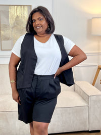 Adoptez ce short noir grande taille femme, à la fois confortable et facile à porter. Sa taille élastiquée assure un maintien optimal, complétée par une fermeture bouton et zip éclair. Sans passants, il offre une coupe épurée et dispose de deux poches à l’avant pratiques pour le quotidien.