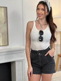 Adoptez ce short en coton femme taille haute, confortable et tendance. Doté de volants sur le haut pour une touche féminine, il se ferme par deux boutons et un zip. Ses deux poches à l’avant et ses revers en bas complètent son style. En gris foncé, il s’associe facilement à toutes vos tenues.
