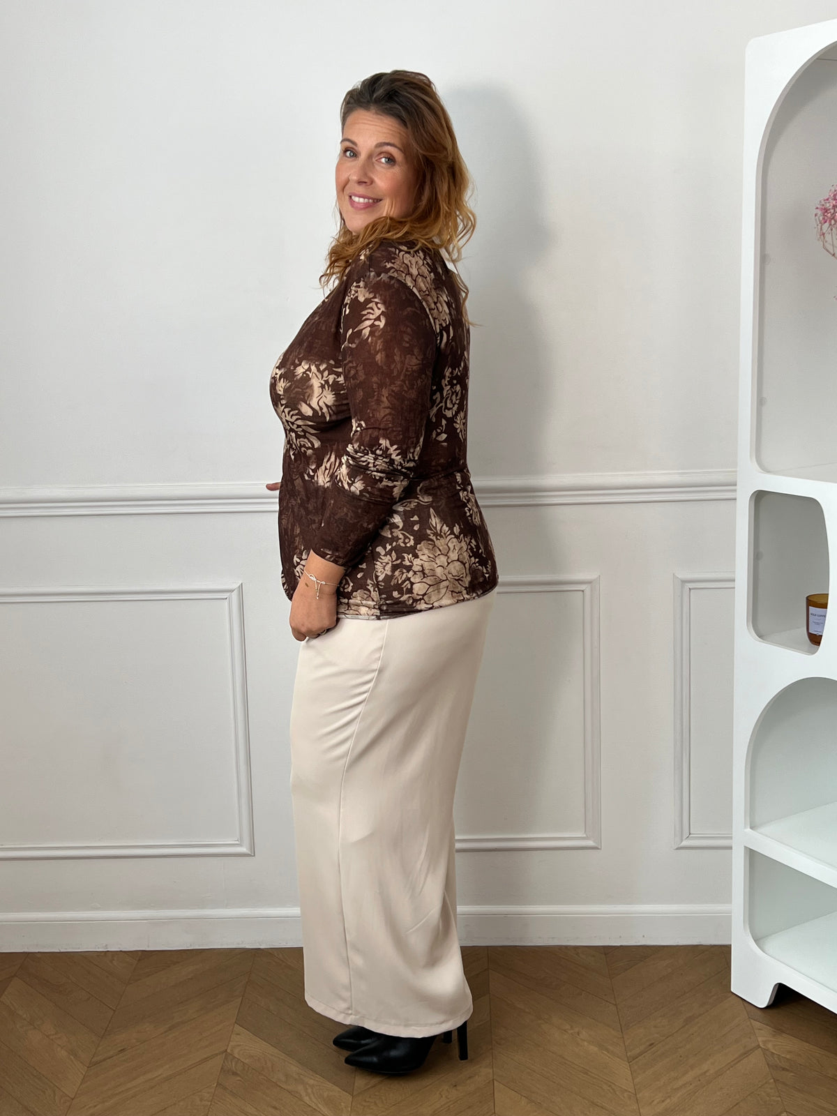 Sous-pull marron Esperanza porté de profil, montrant les motifs floraux beiges et la longueur sur les hanches.