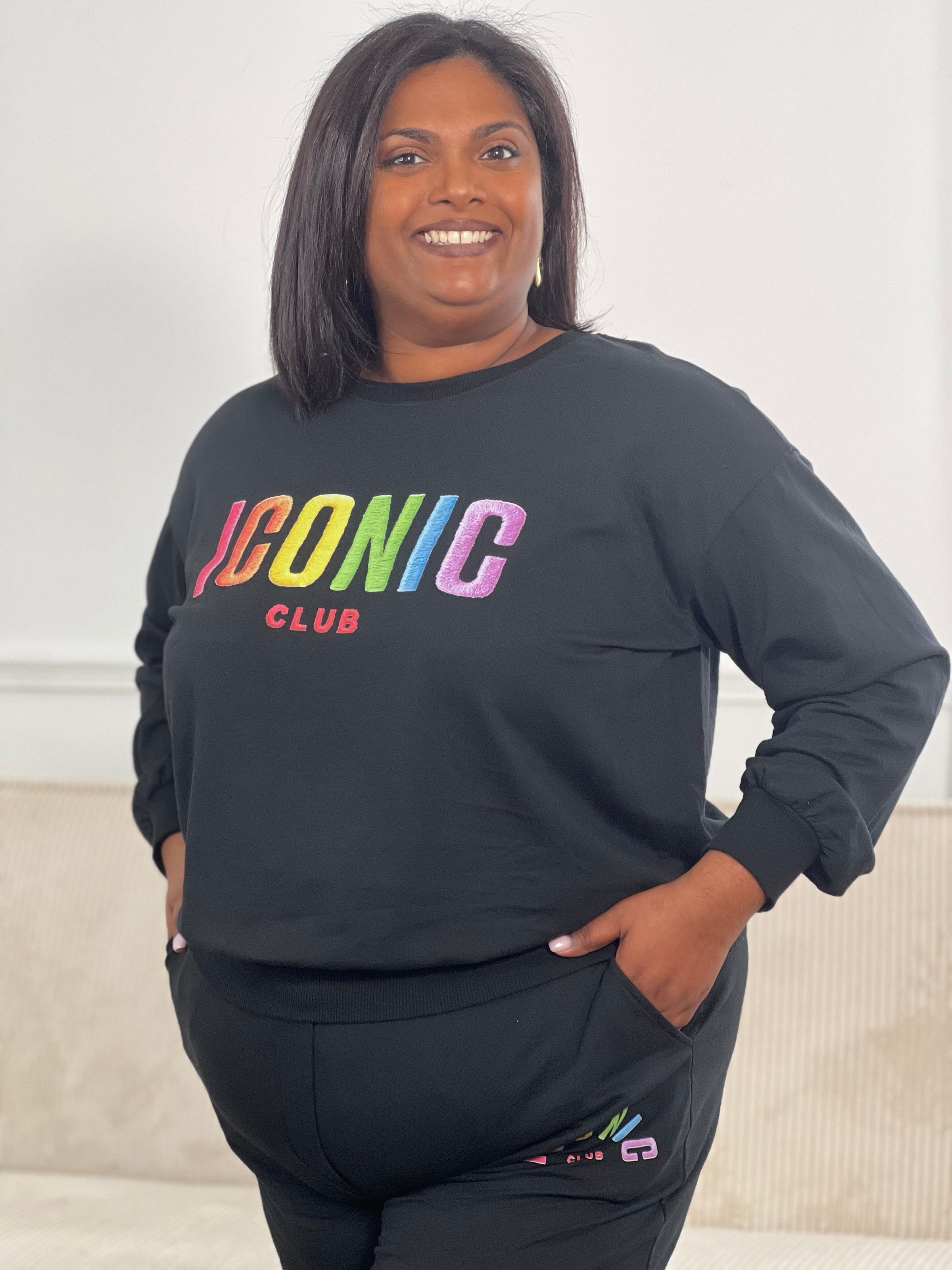 Pull grande taille noir à manches longues avec col rond, orné de l’inscription "Iconic club" en doré pour une touche féminine et raffinée.