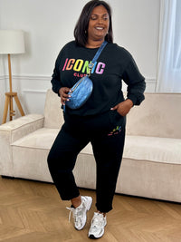 Pull grande taille noir à manches longues avec col rond, orné de l’inscription "Iconic club" en doré pour une touche féminine et raffinée.