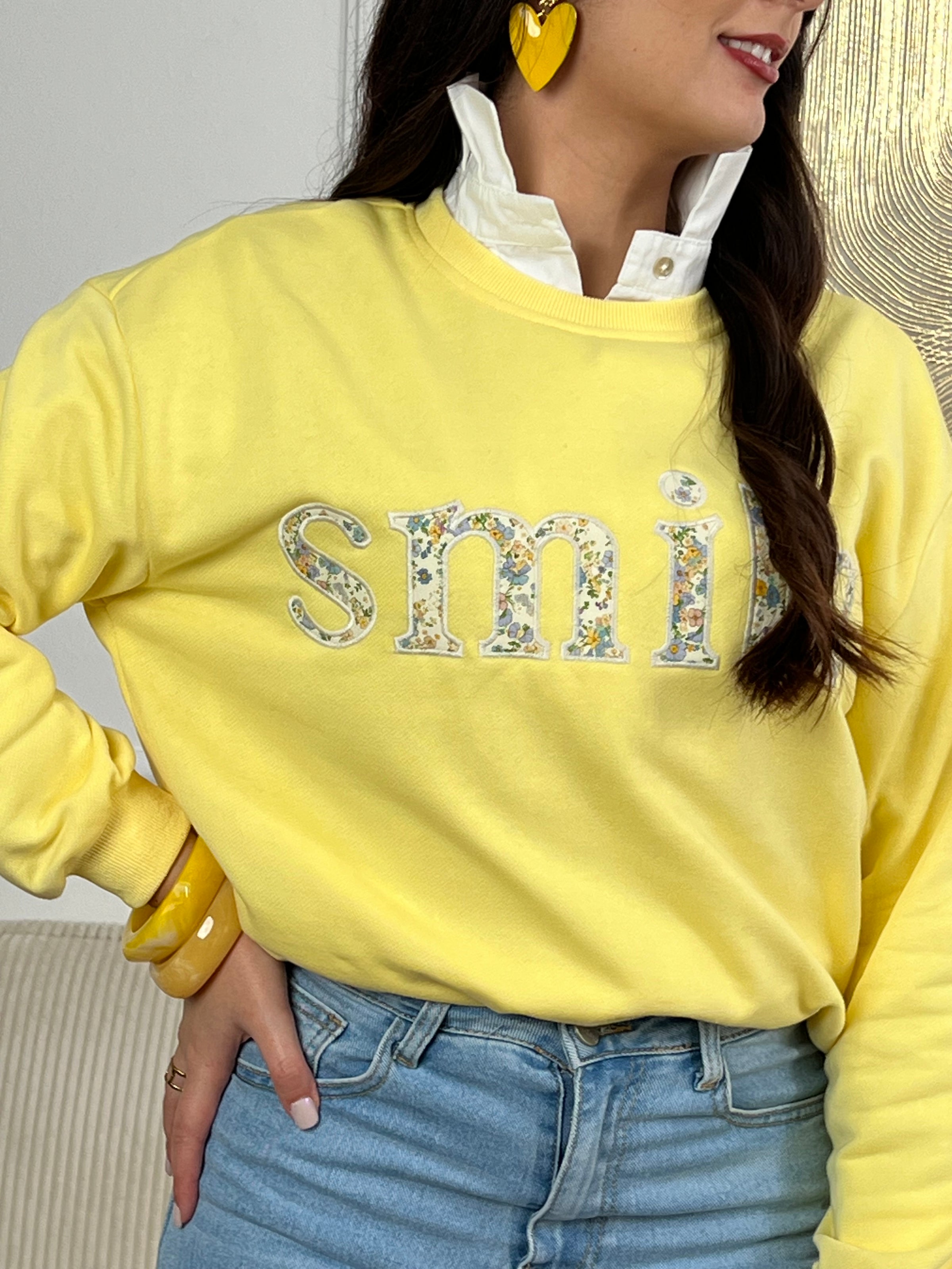 Sweat jaune confortable aux manches longues, parfait pour les journées fraîches. Son col rond classique offre une allure intemporelle, tandis que l'inscription "SMILE" brodée avec des motifs fleuris délicats ajoute une touche de personnalité et de douceur. Un basique polyvalent à porter seul ou en superposition, idéal pour exprimer votre style avec bienveillance.