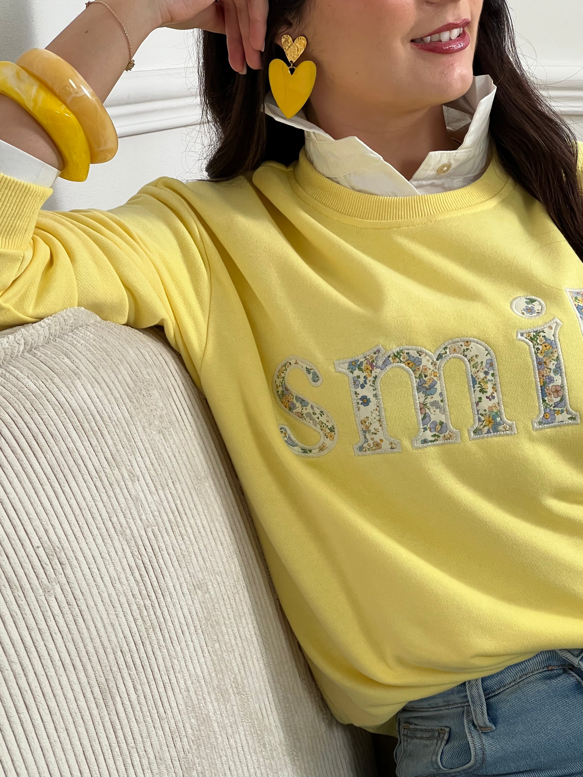 Sweat jaune confortable aux manches longues, parfait pour les journées fraîches. Son col rond classique offre une allure intemporelle, tandis que l'inscription "SMILE" brodée avec des motifs fleuris délicats ajoute une touche de personnalité et de douceur. Un basique polyvalent à porter seul ou en superposition, idéal pour exprimer votre style avec bienveillance.