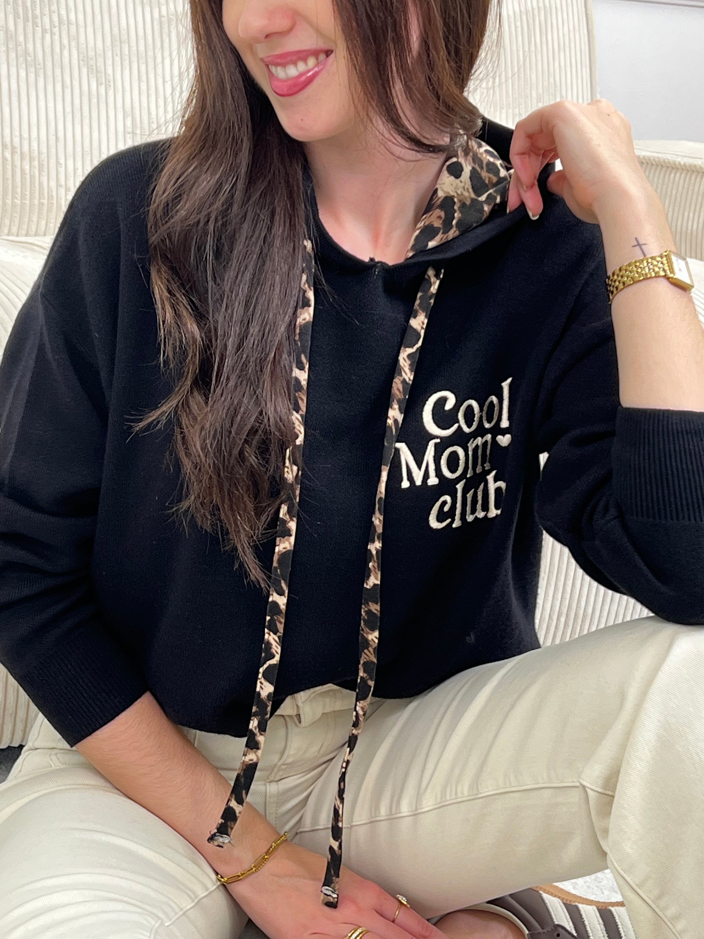 Rejoignez le "Cool mom club" avec notre pull noir à capuche Naelya. Les cordons léopards apportent une touche de style, tandis que l'intérieur léopard de la capuche vous garde au chaud. Les manches longues vous offrent confort et praticité.