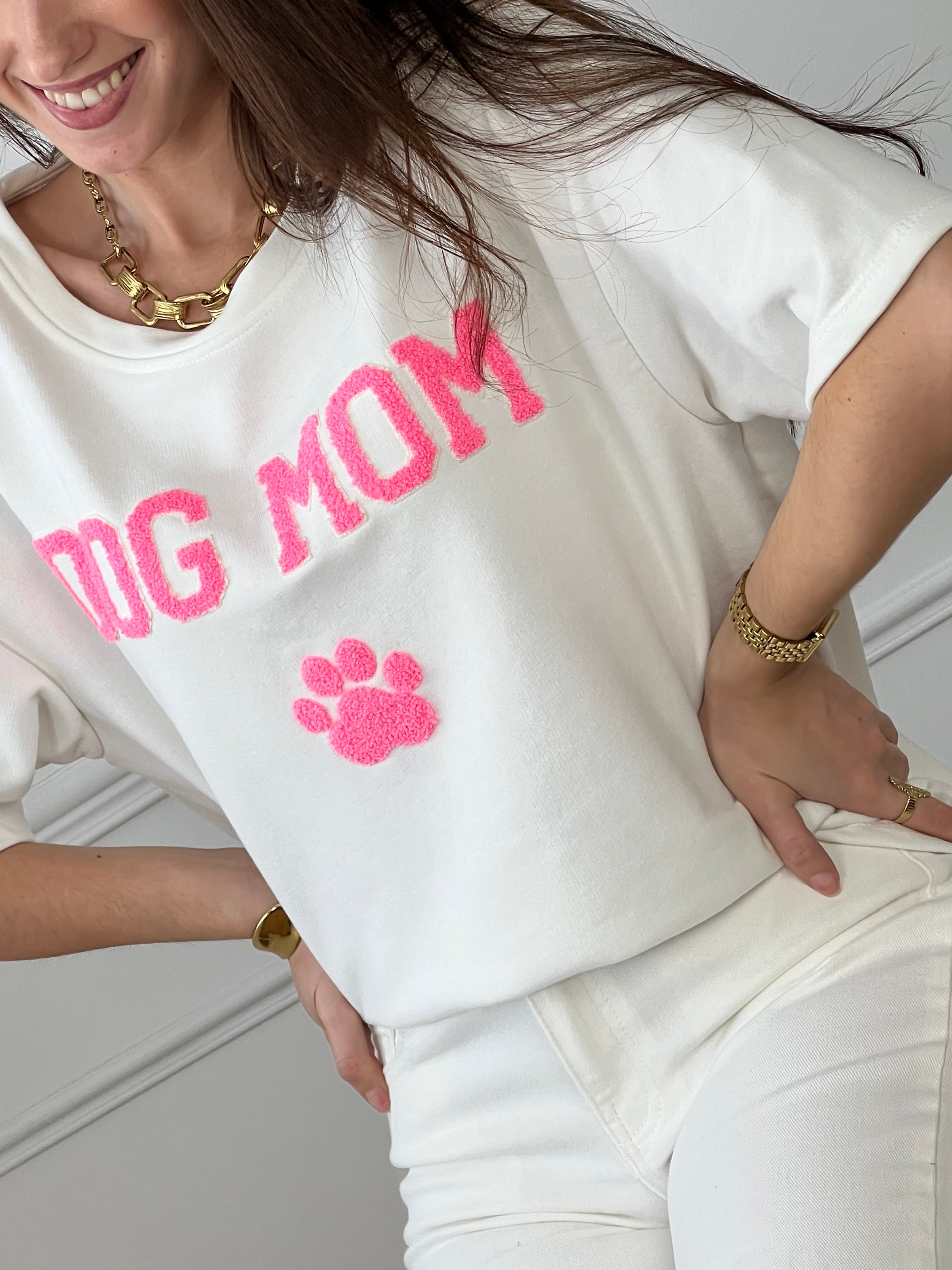 Craquez pour ce tee-shirt style sweat femme, confortable et tendance. Doté de manches courtes et d’un col rond, il est confectionné en 100 % coton pour un confort optimal. Son inscription “Dog mom” en rose et écru avec une patte de chien apporte une touche fun et originale.