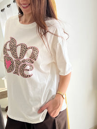 Tee-shirt blanc femme avec inscription "Amore" en motif léopard, parfait pour un look tendance et féminin. Conçu en 100% coton, il offre un confort optimal au quotidien grâce à ses manches courtes et son col rond. Ses touches de couleurs rose, beige, noir et marron apportent une note originale et facile à assortir. Un basique revisité, idéal pour un style chic et décontracté.