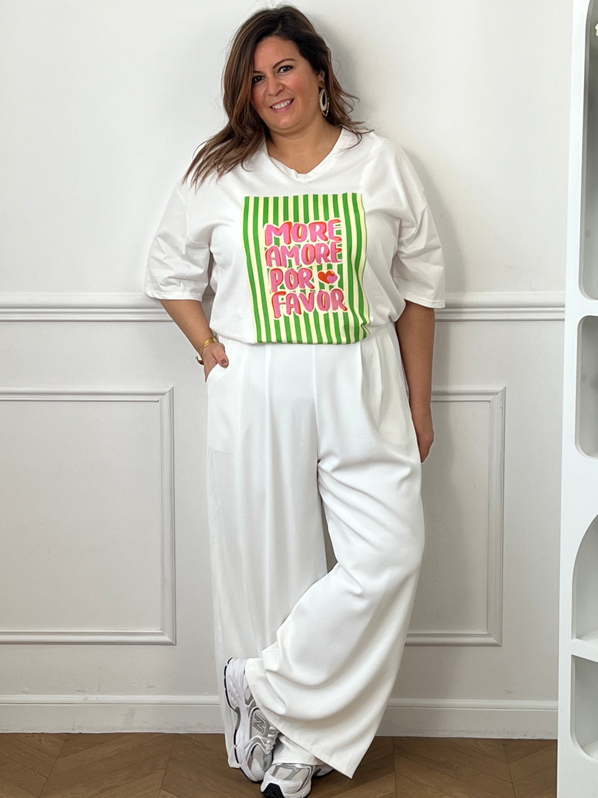 Ajoutez une touche de bonne humeur à votre dressing avec ce tee-shirt blanc femme au message tendance « More amore por favor » en rose et orange. Son col V et ses manches courtes offrent une coupe féminine et confortable, tandis que les rayures verticales vertes et beiges apportent une note originale et estivale.