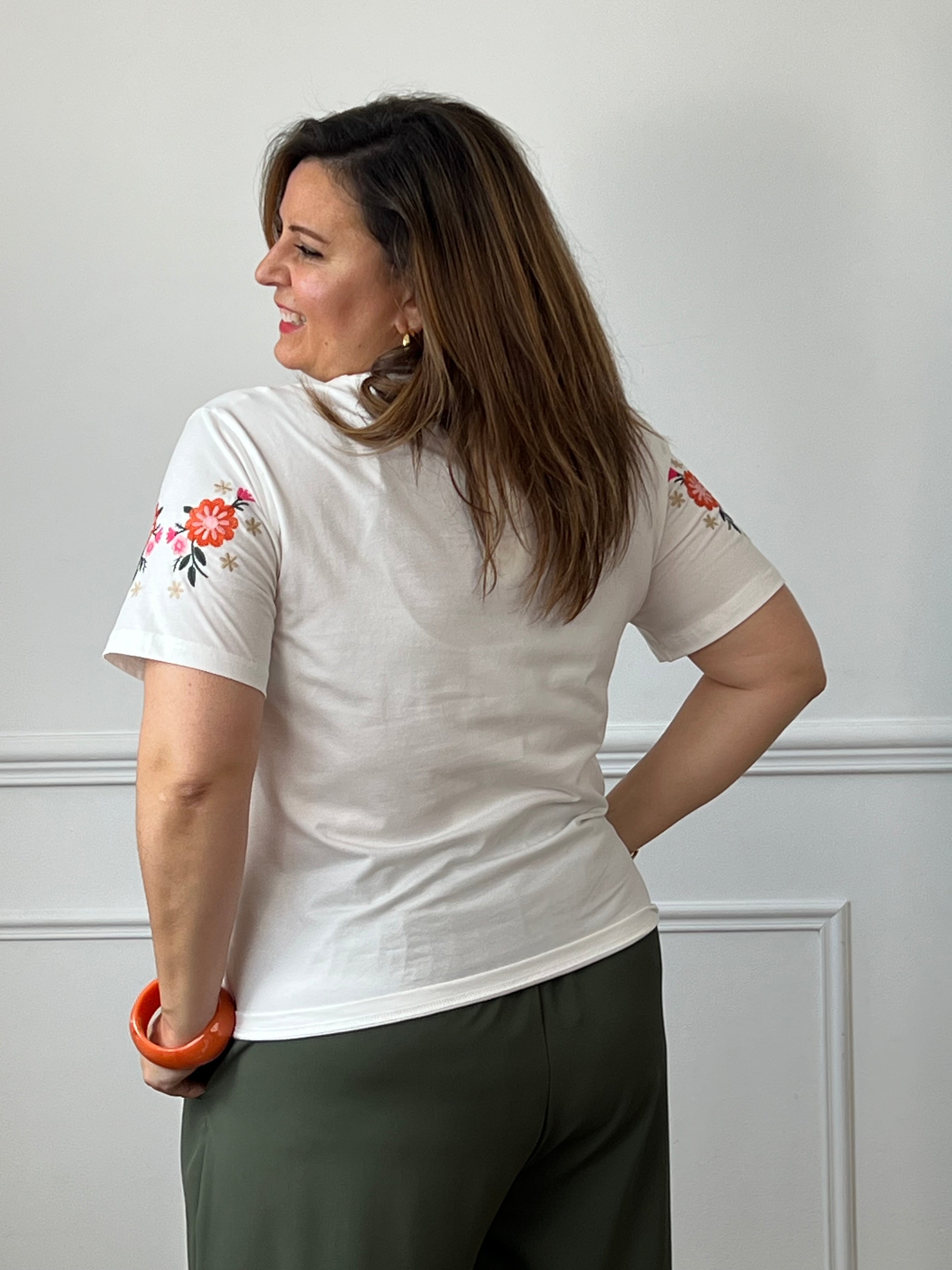 Vue de dos du tee-shirt blanc femme avec détails de fleurs brodées sur les épaules.
