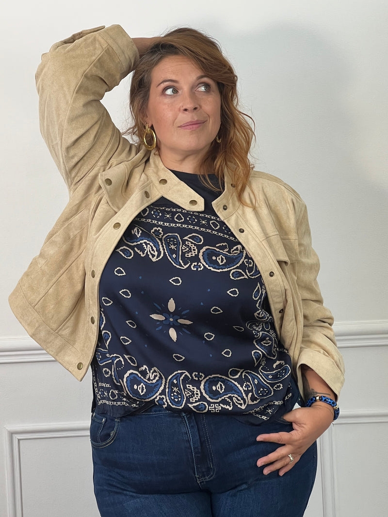 ee-shirt bleu marine Livana à motifs cachemire écrus et bleus, porté sous une veste beige avec un jean.