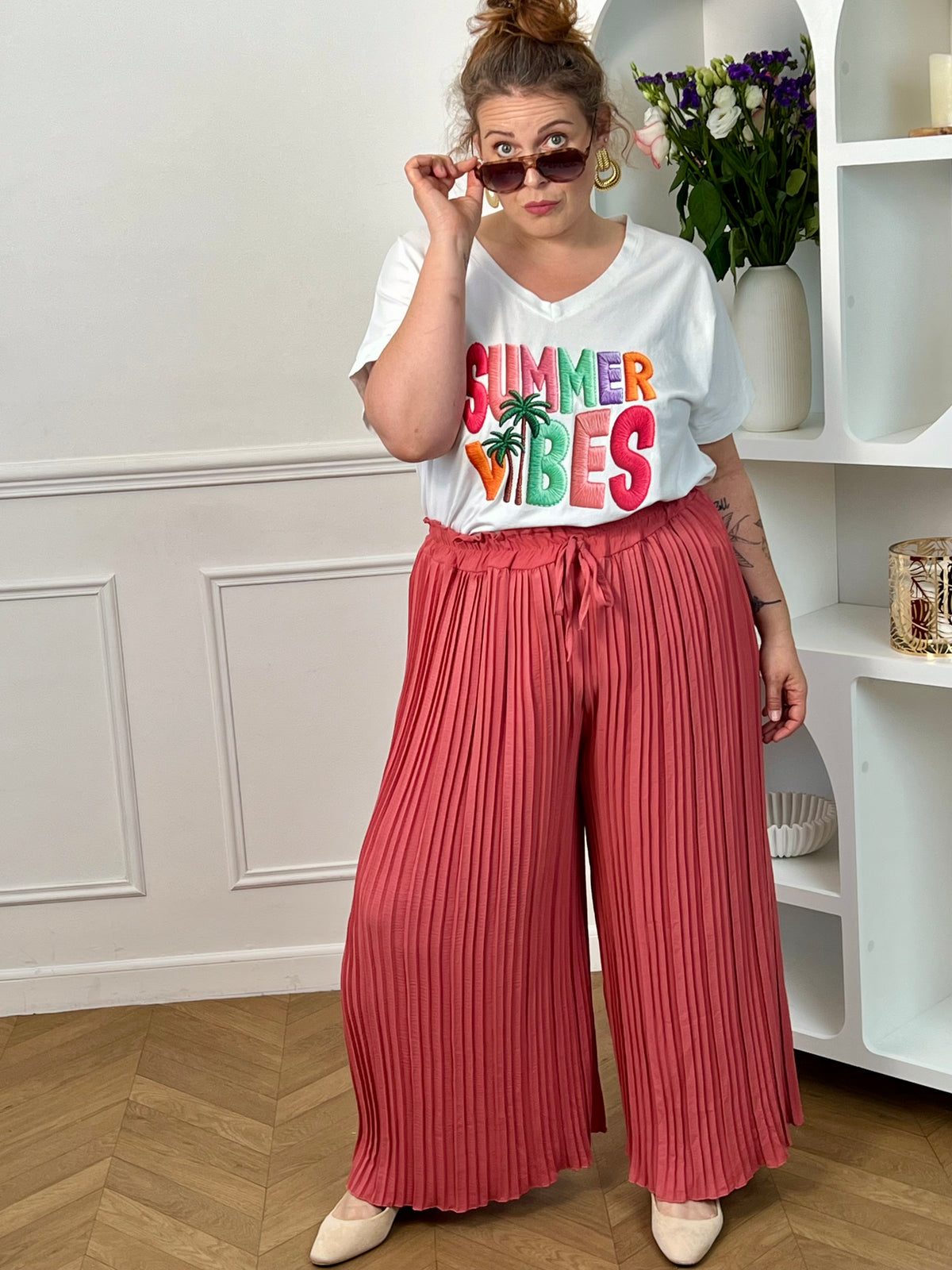 Tee-shirt blanc femme à manches courtes, parfait pour un look estival et décontracté. Avec son col V et son imprimé coloré "Summer Vibes" accompagné d’un motif palmier, il apporte une touche tendance et ensoleillée à vos tenues. Facile à associer, ce tee-shirt aux nuances rose, vert, violet et orange est idéal pour un style casual chic au quotidien.