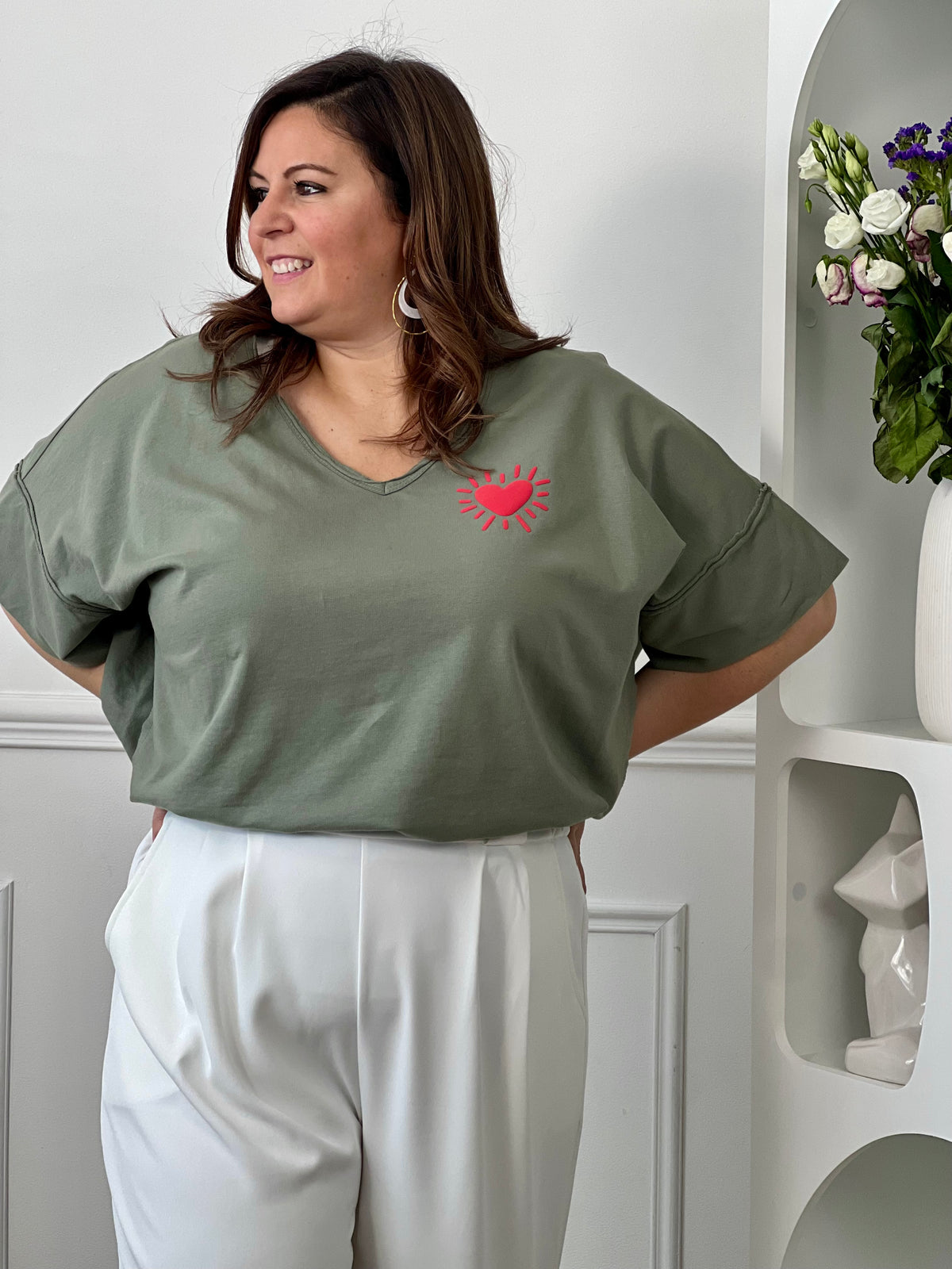 Tee-shirt kaki basique femme grande taille, parfait pour un look décontracté et tendance. Avec ses manches courtes, son col V et son cœur rouge floqué, il apporte une touche féminine et moderne. Confectionné en coton avec une pointe d’élasthanne, il offre confort, douceur et liberté de mouvement. Facile à associer, ce tee-shirt kaki est un indispensable du dressing grande taille.