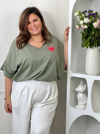 Tee-shirt kaki basique femme grande taille, parfait pour un look décontracté et tendance. Avec ses manches courtes, son col V et son cœur rouge floqué, il apporte une touche féminine et moderne. Confectionné en coton avec une pointe d’élasthanne, il offre confort, douceur et liberté de mouvement. Facile à associer, ce tee-shirt kaki est un indispensable du dressing grande taille.