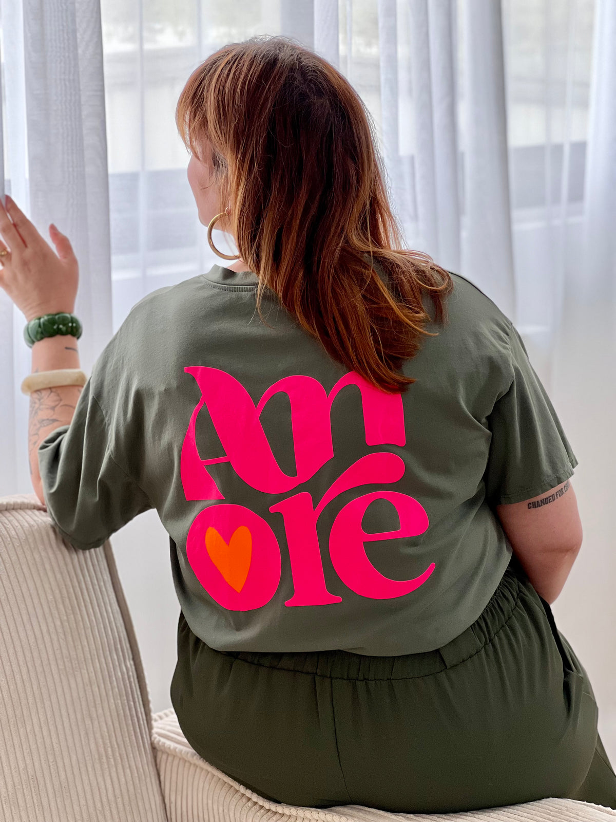 Tee-shirt kaki grande taille femme, confortable et tendance. Doté de manches courtes et d’un col V, il se distingue par son inscription “Amore” sur le devant et au dos. Ses touches de rose et d’orange fluo apportent une note moderne et dynamique à votre look.