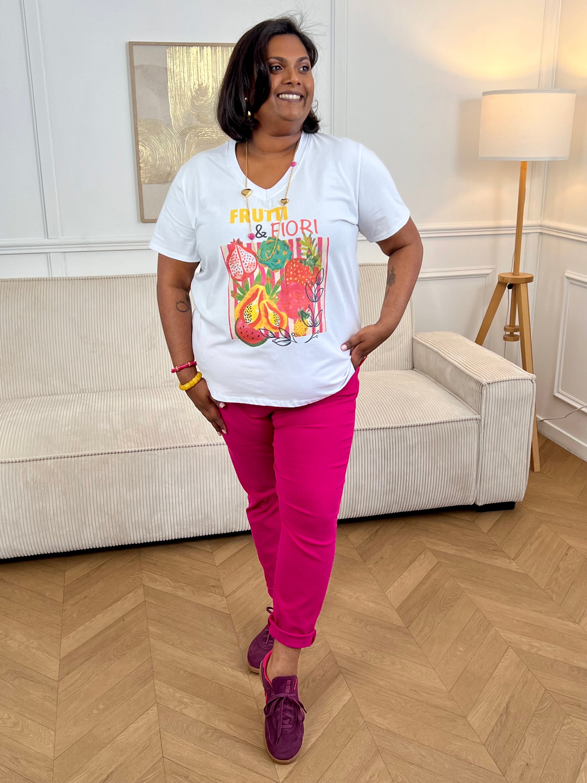 Tee-shirt écru grande taille pour femme, idéal pour un look frais et tendance. Doté de manches courtes et d’un col V flatteur, il se distingue par ses illustrations de fruits colorés et l’inscription « Frutti &amp; Flori ». Ses motifs aux tons orange, rose, jaune, rouge et noir apportent une touche estivale et originale à cette pièce confortable et facile à porter au quotidien.