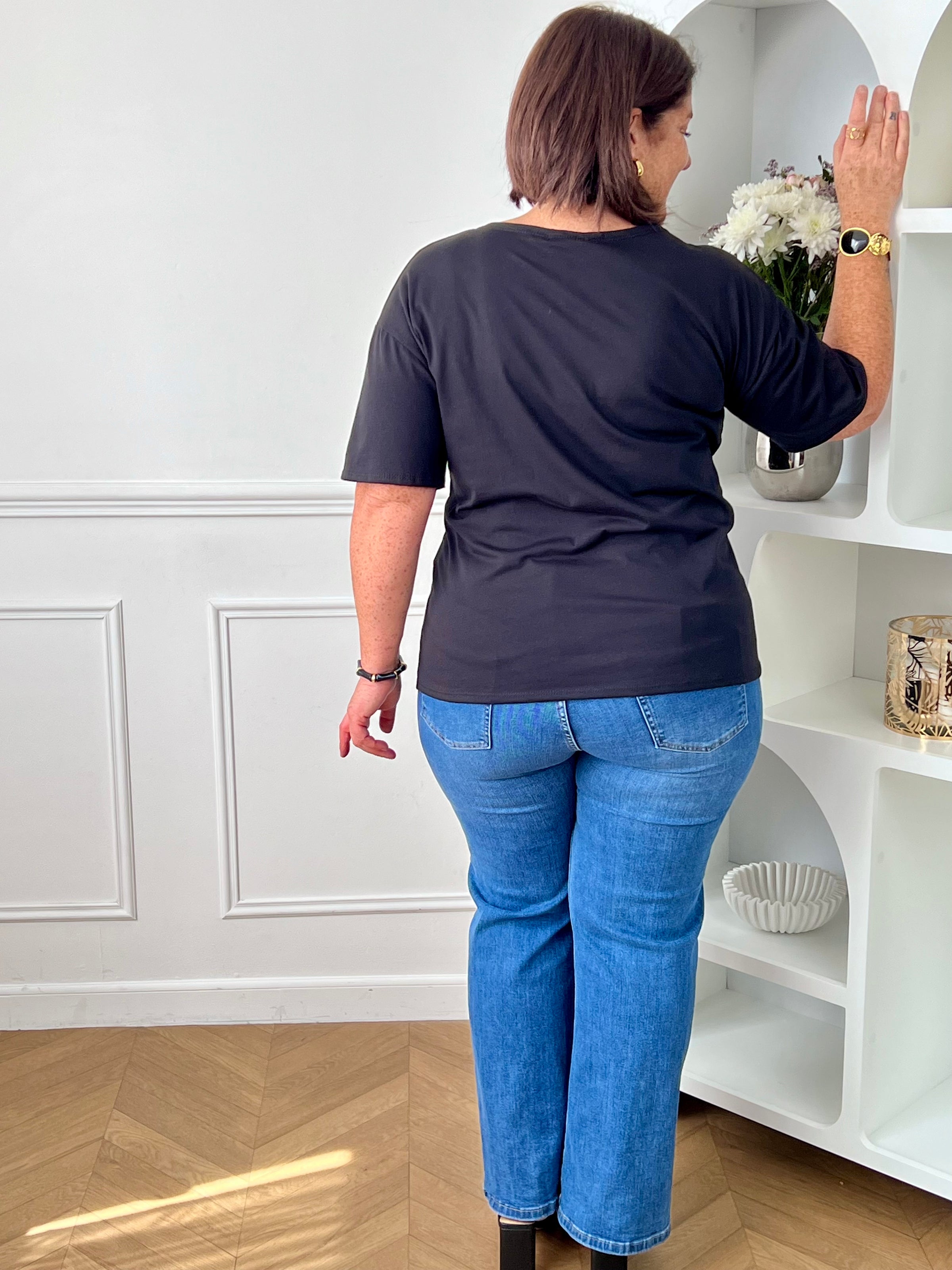 Découvrez ce tee-shirt noir élégant et féminin, parfait pour apporter une touche chic à vos tenues du quotidien. Sa coupe cintrée met en valeur la silhouette tandis que son col rond et ses manches courtes assurent un confort optimal. La broche dorée amovible sur le devant ajoute une note sophistiquée et tendance, idéale pour personnaliser votre style selon vos envies.