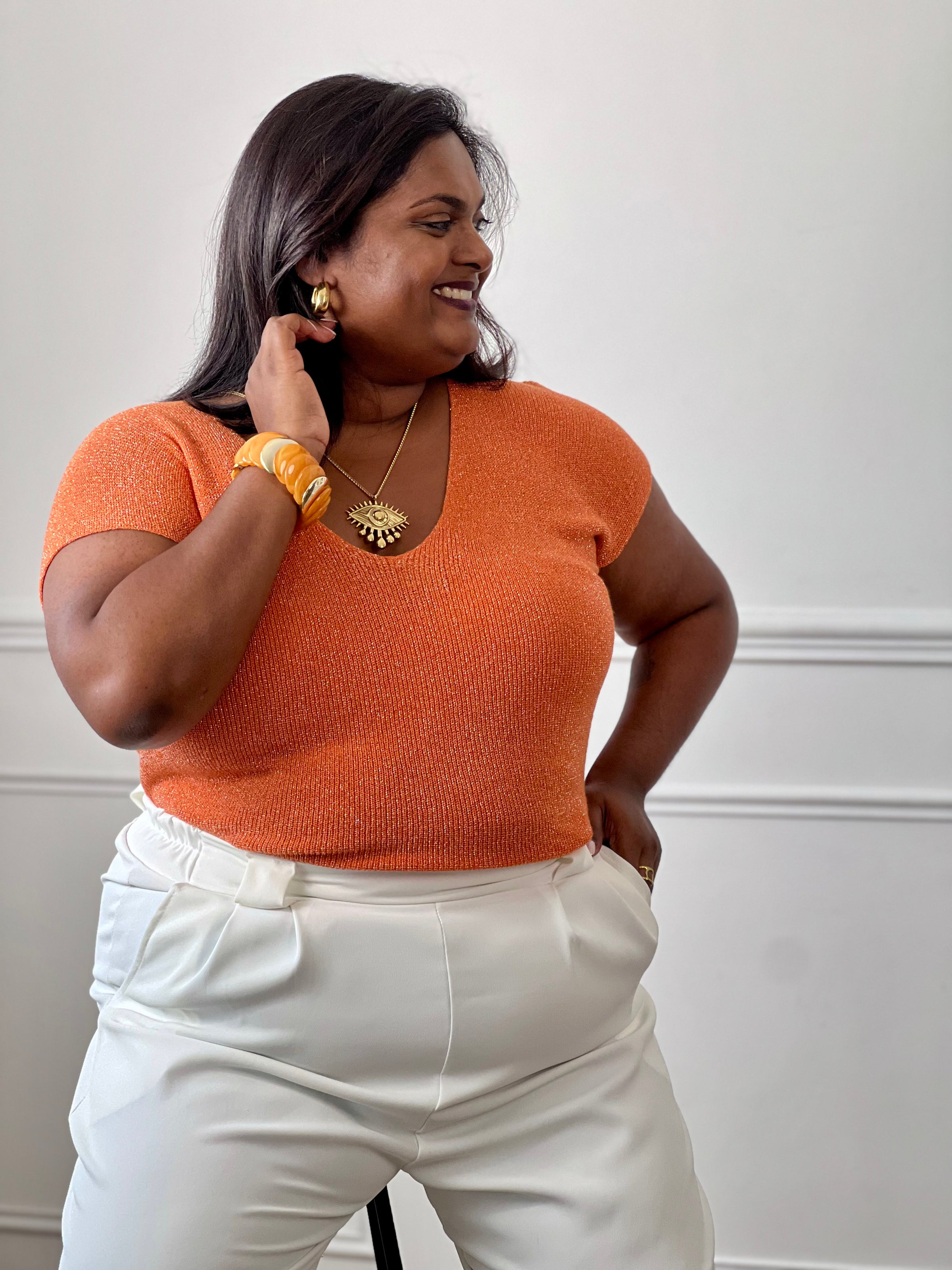 Tee-shirt orange femme grande taille sans manches, doté d’un élégant col V et rehaussé de délicats fils de lurex argenté brillant. Sa coupe confortable et féminine met en valeur la silhouette tout en apportant une touche lumineuse et tendance à vos tenues du quotidien comme de soirée. Un indispensable pour allier confort, style et éclat.&nbsp;