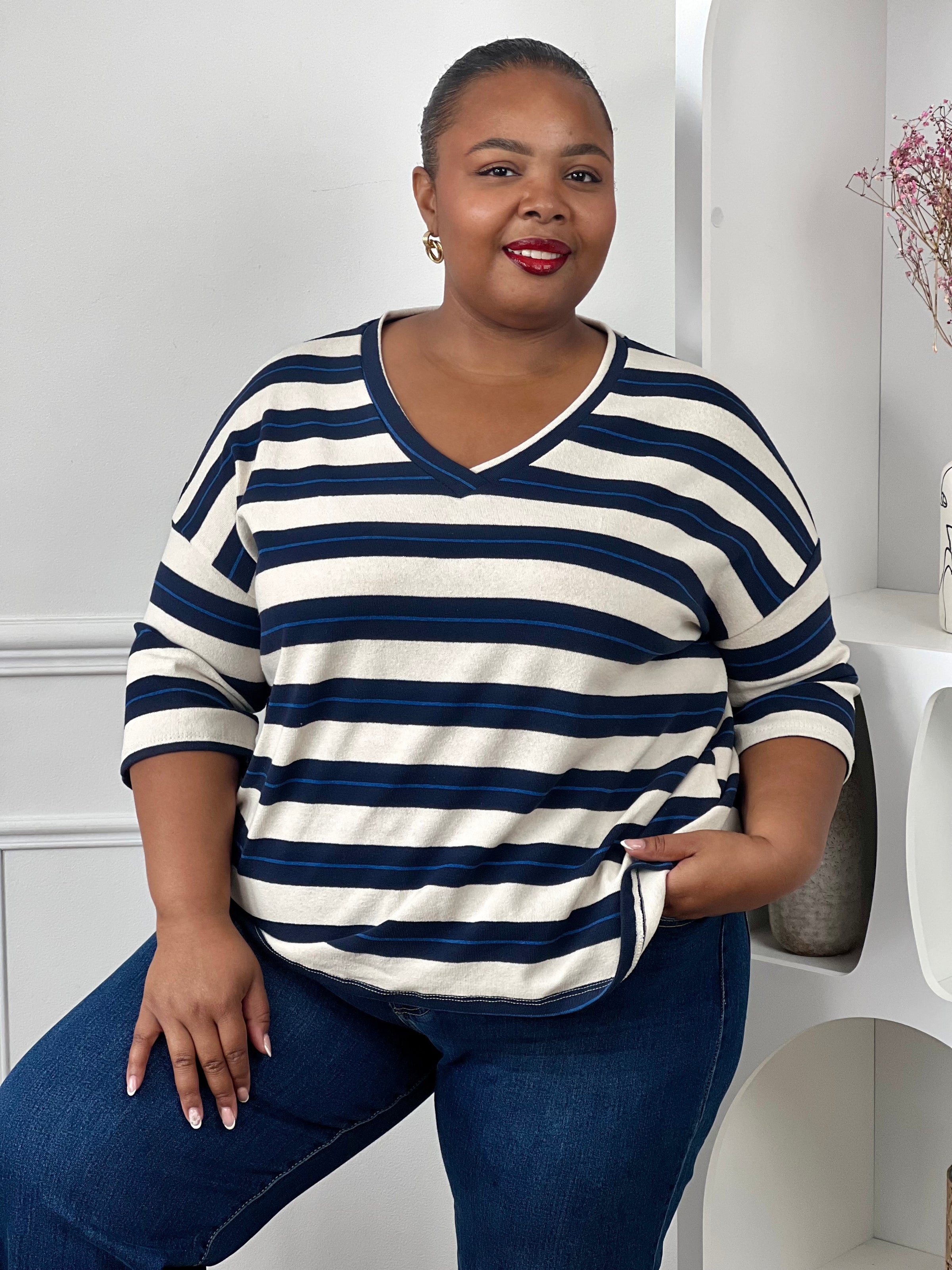 Tee-shirt rayé grande taille en coton porté avec un jean bleu pour un look décontracté.