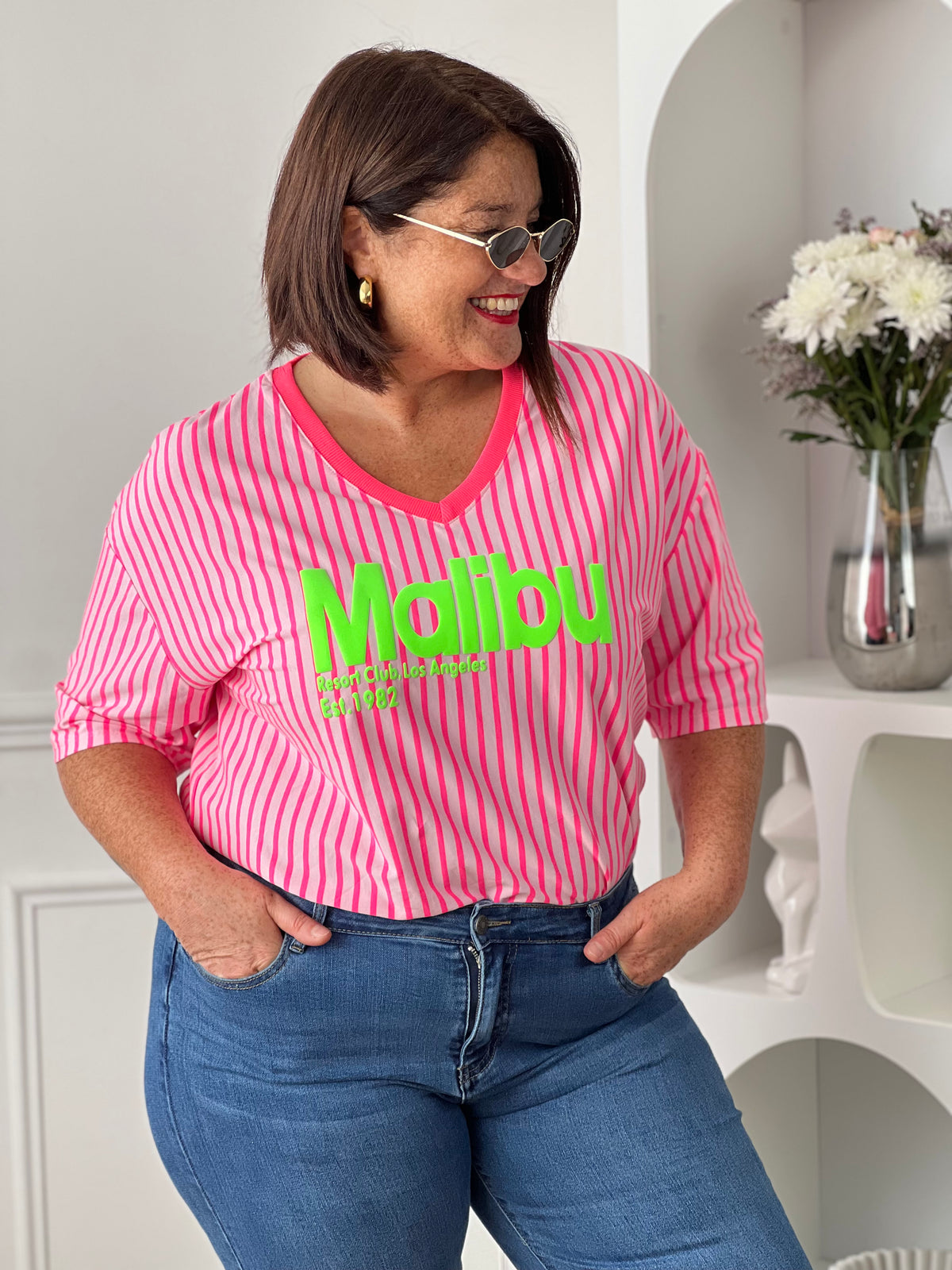 Ajoutez une touche de peps à votre dressing avec ce tee-shirt rose fluo au style résolument tendance. Confectionné en 100% coton, il offre un confort optimal au quotidien grâce à sa matière douce et légère. L’inscription vert fluo « Malibu » apporte une note estivale et dynamique. Les rayures verticales rose fluo et rose clair complètent son look moderne et coloré, idéal pour illuminer vos tenues décontractées.