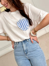 Craquez pour ce tee-shirt écru femme à manches courtes, confortable et plein de charme. Confectionné en 100 % coton, il présente un col rond classique et un empiècement en forme de cœur à rayures pour une touche originale. Ses teintes écru et bleu en font un basique facile à associer au quotidien.