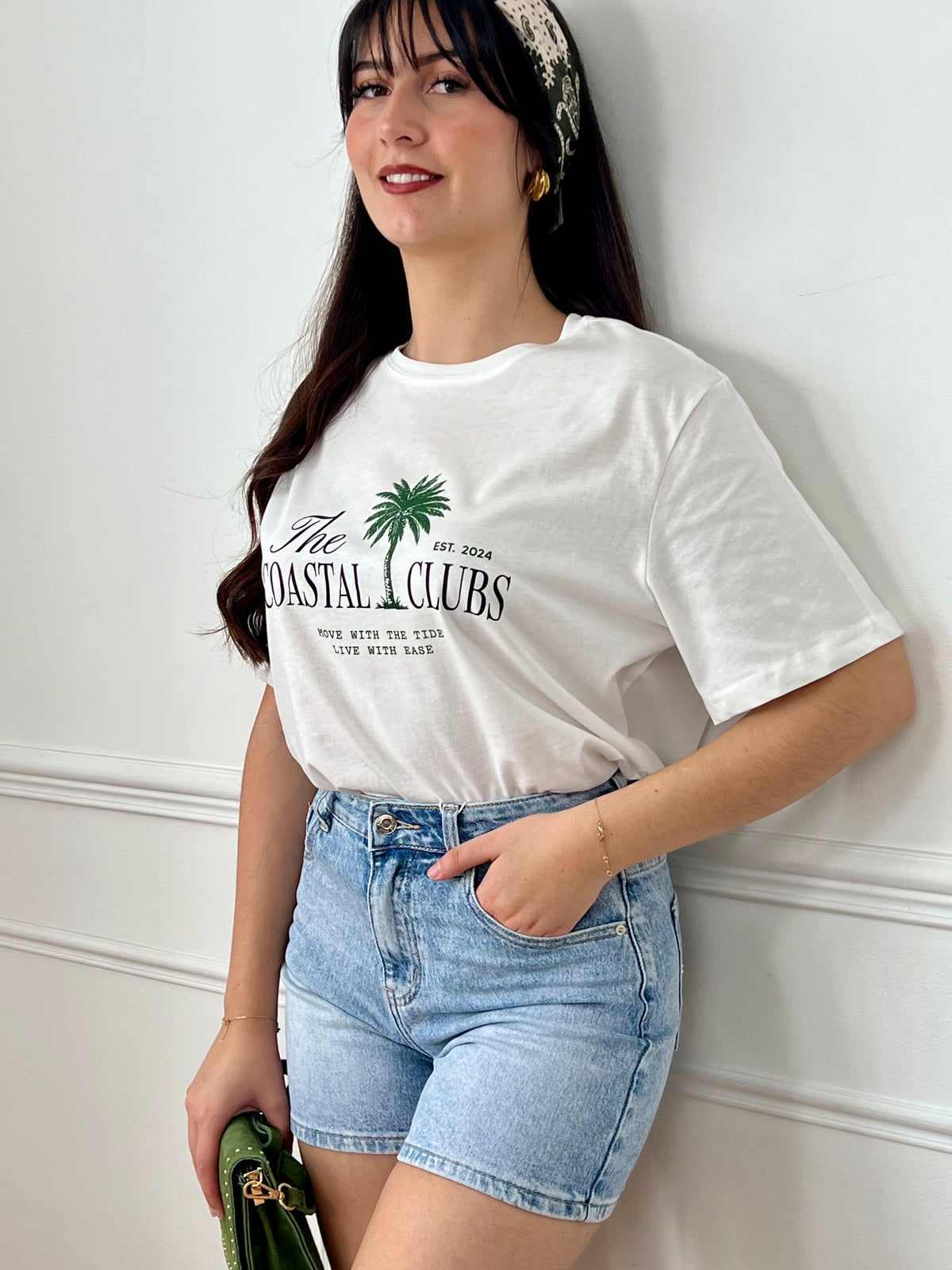 Tee-shirt écru femme à manches courtes, parfait pour un look décontracté et tendance. Avec son col rond et son imprimé "The Coastal Clubs" accompagné d’un motif palmier, il apporte une touche estivale et moderne. Facile à associer, ce tee-shirt aux tons écru, vert et noir est idéal pour compléter vos tenues casual du quotidien.