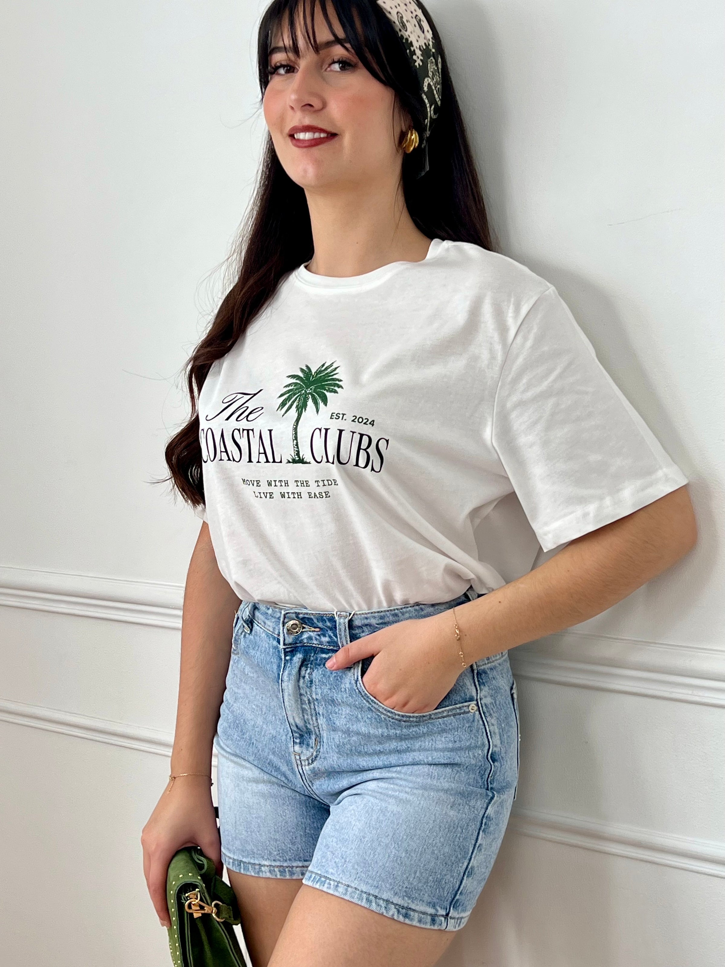 Tee-shirt écru femme à manches courtes, parfait pour un look décontracté et tendance. Avec son col rond et son imprimé "The Coastal Clubs" accompagné d’un motif palmier, il apporte une touche estivale et moderne. Facile à associer, ce tee-shirt aux tons écru, vert et noir est idéal pour compléter vos tenues casual du quotidien.