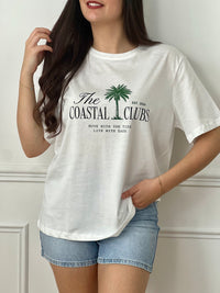 Tee-shirt écru femme à manches courtes, parfait pour un look décontracté et tendance. Avec son col rond et son imprimé "The Coastal Clubs" accompagné d’un motif palmier, il apporte une touche estivale et moderne. Facile à associer, ce tee-shirt aux tons écru, vert et noir est idéal pour compléter vos tenues casual du quotidien.