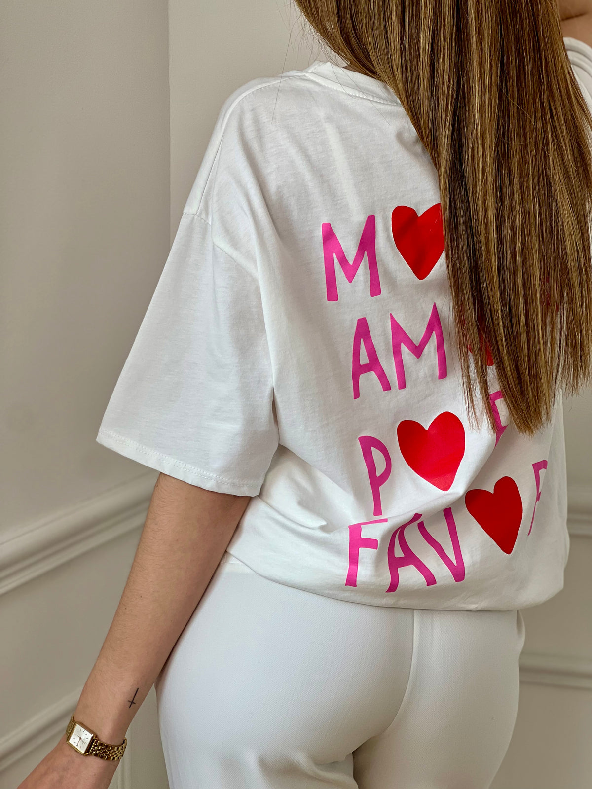 Top écru femme à manches courtes, parfait pour un look tendance et décontracté. Avec son col rond et son inscription rose "More Amore Por Favor" à l’avant et au dos, il apporte une touche originale et moderne. Son détail cœur rouge ajoute une note féminine et stylée.