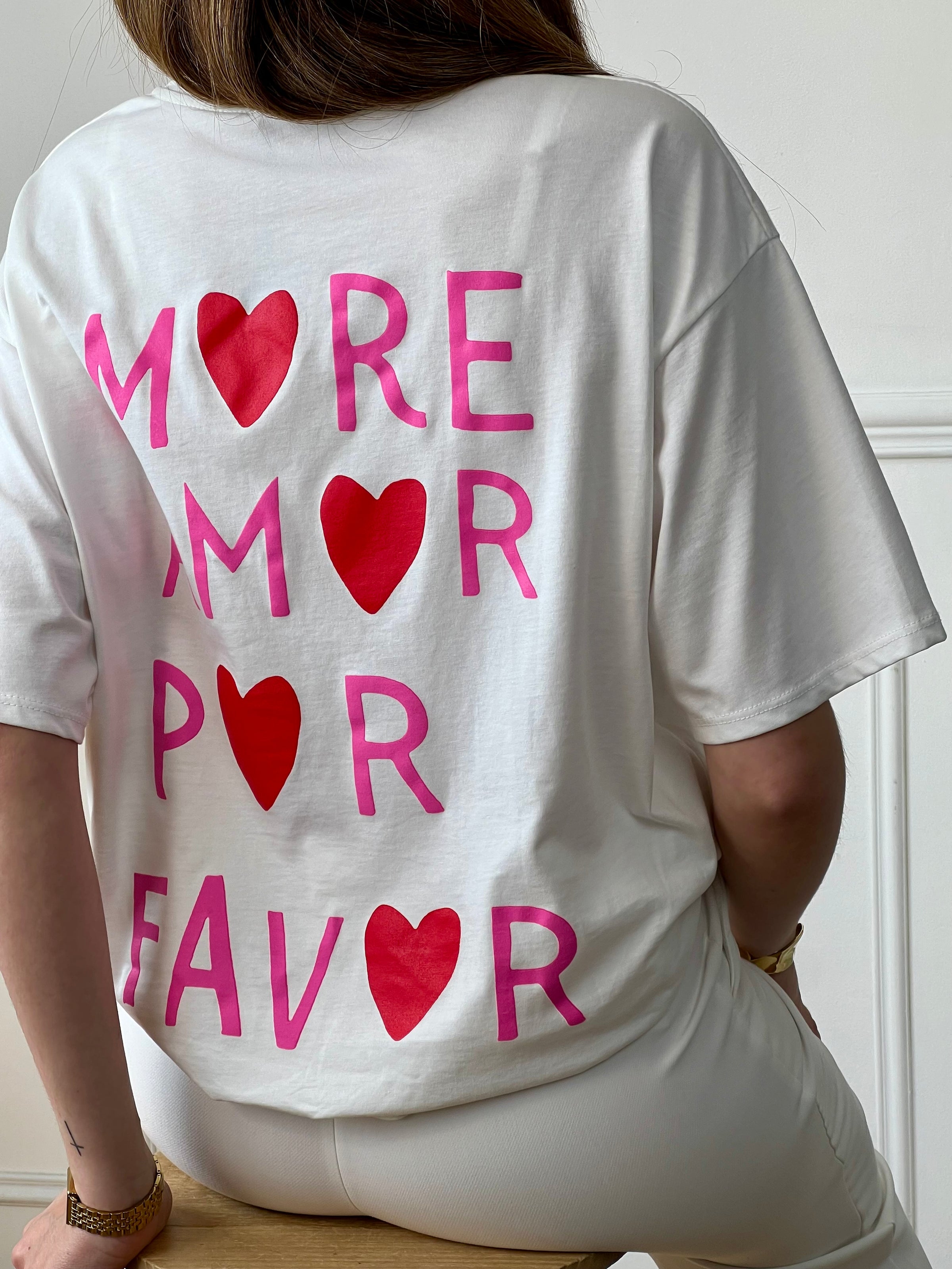 Top écru femme à manches courtes, parfait pour un look tendance et décontracté. Avec son col rond et son inscription rose "More Amore Por Favor" à l’avant et au dos, il apporte une touche originale et moderne. Son détail cœur rouge ajoute une note féminine et stylée.