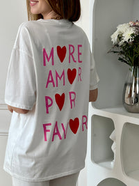 Top écru femme à manches courtes, parfait pour un look tendance et décontracté. Avec son col rond et son inscription rose "More Amore Por Favor" à l’avant et au dos, il apporte une touche originale et moderne. Son détail cœur rouge ajoute une note féminine et stylée.