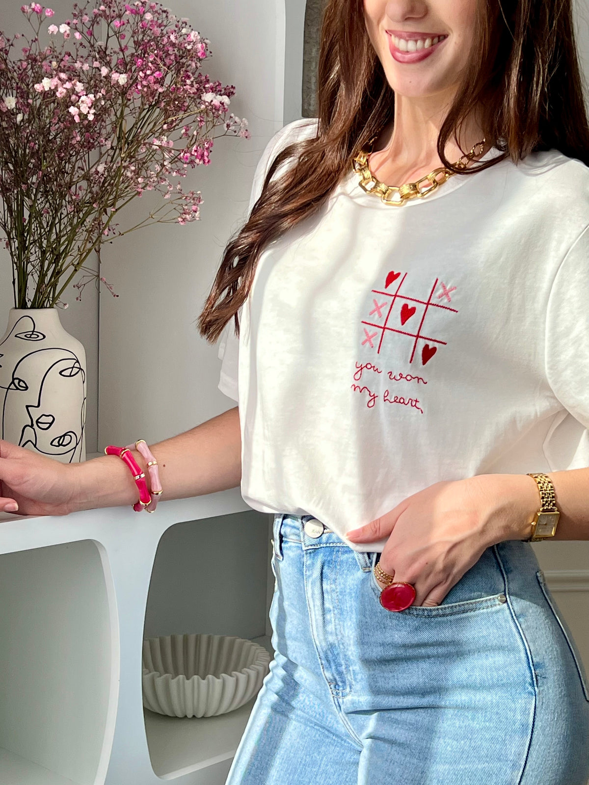 Craquez pour ce tee-shirt écru femme à manches courtes, à la fois doux et original. Doté d’un col rond et d’une inscription brodée “You won my heart” sur le devant et au dos, il est sublimé par des motifs de morpion avec cœurs et croix. Ses couleurs écru, rose et rouge apportent une touche romantique et tendance à votre tenue.