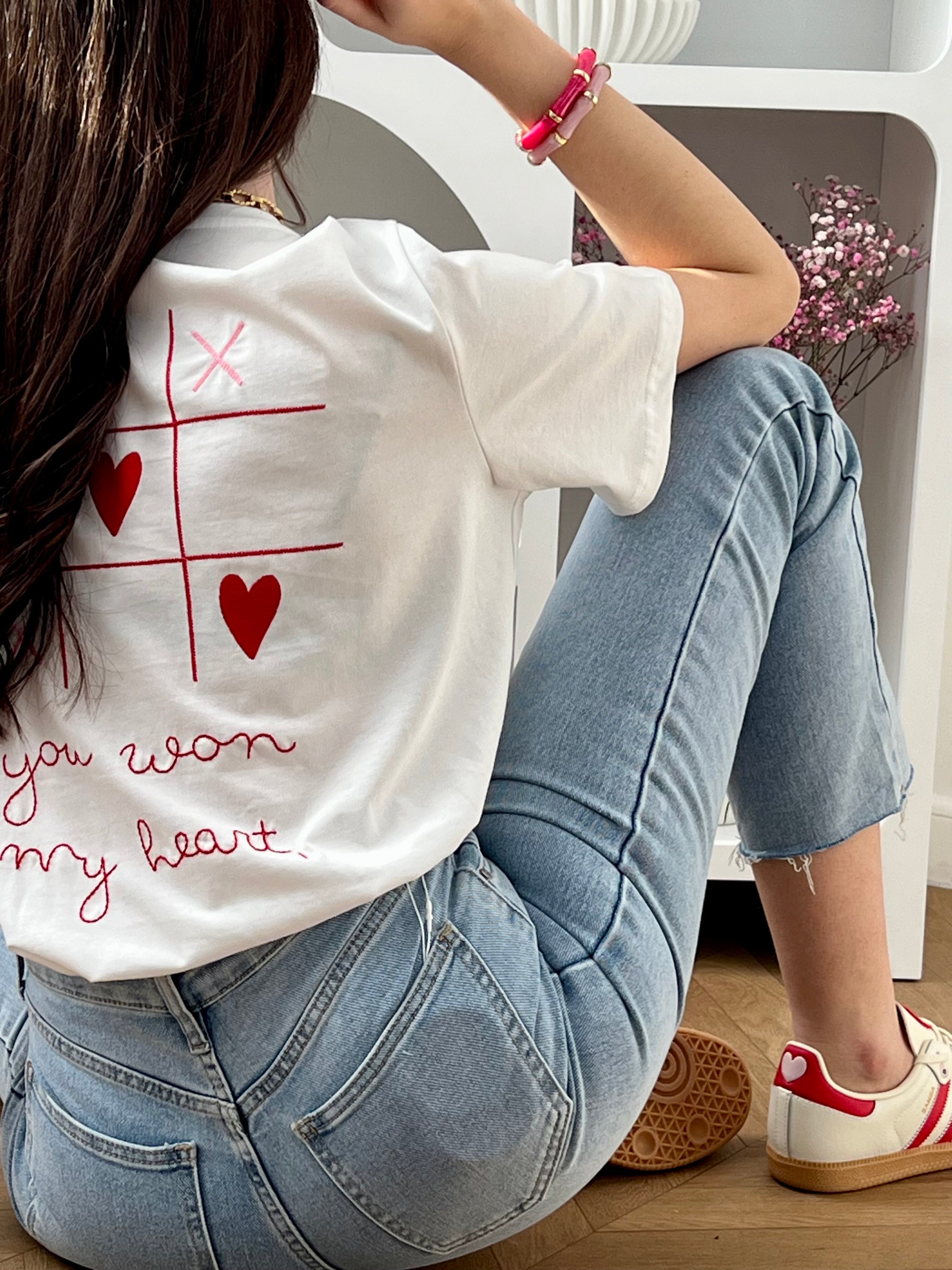 Craquez pour ce tee-shirt écru femme à manches courtes, à la fois doux et original. Doté d’un col rond et d’une inscription brodée “You won my heart” sur le devant et au dos, il est sublimé par des motifs de morpion avec cœurs et croix. Ses couleurs écru, rose et rouge apportent une touche romantique et tendance à votre tenue.