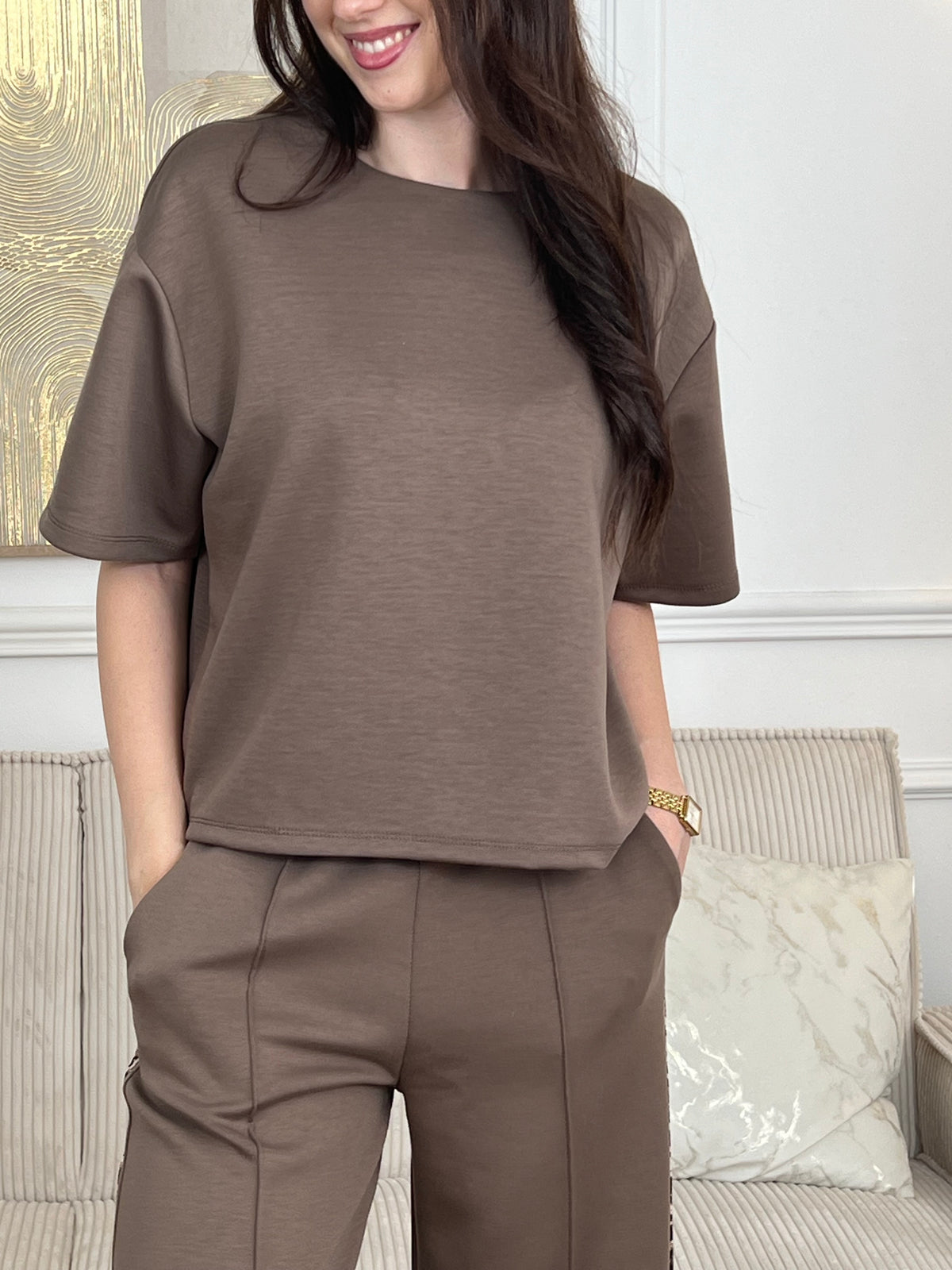 Notre tee-shirt Nilo en taupe est le basique indispensable pour construire une garde-robe sans effort. Réalisé dans une matière épaisse qui assure confort et tenue, il propose une coupe généreuse qui met en valeur chaque silhouette. Avec ses manches courtes et son col rond intemporel, ce top s'associe facilement à tous vos essentiels, notamment au jogging Nilo pour un look coordonné et décontracté.