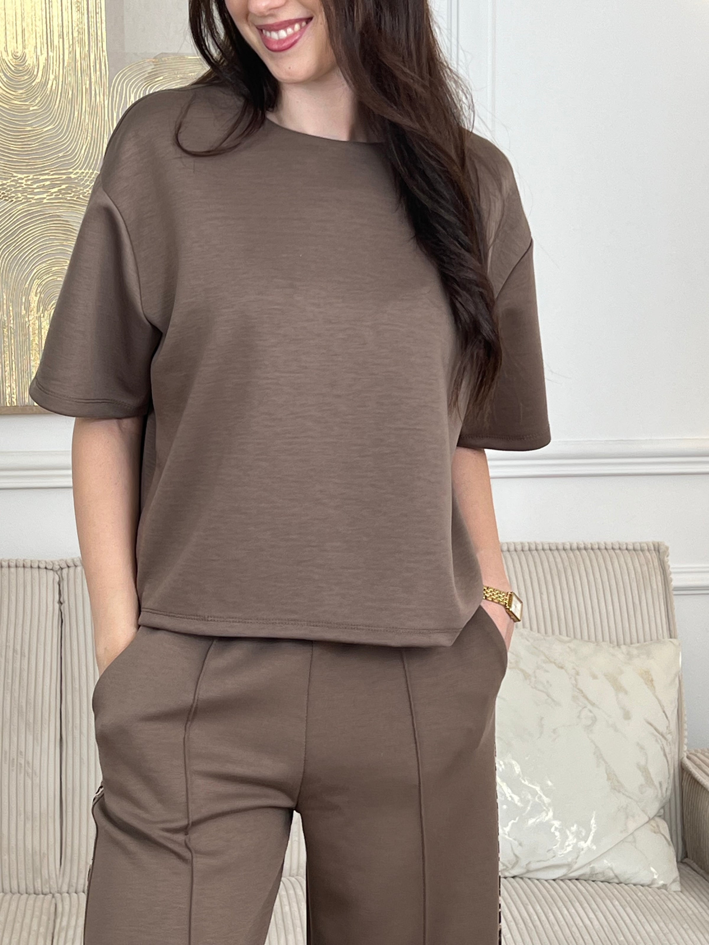 Notre tee-shirt Nilo en taupe est le basique indispensable pour construire une garde-robe sans effort. Réalisé dans une matière épaisse qui assure confort et tenue, il propose une coupe généreuse qui met en valeur chaque silhouette. Avec ses manches courtes et son col rond intemporel, ce top s'associe facilement à tous vos essentiels, notamment au jogging Nilo pour un look coordonné et décontracté.