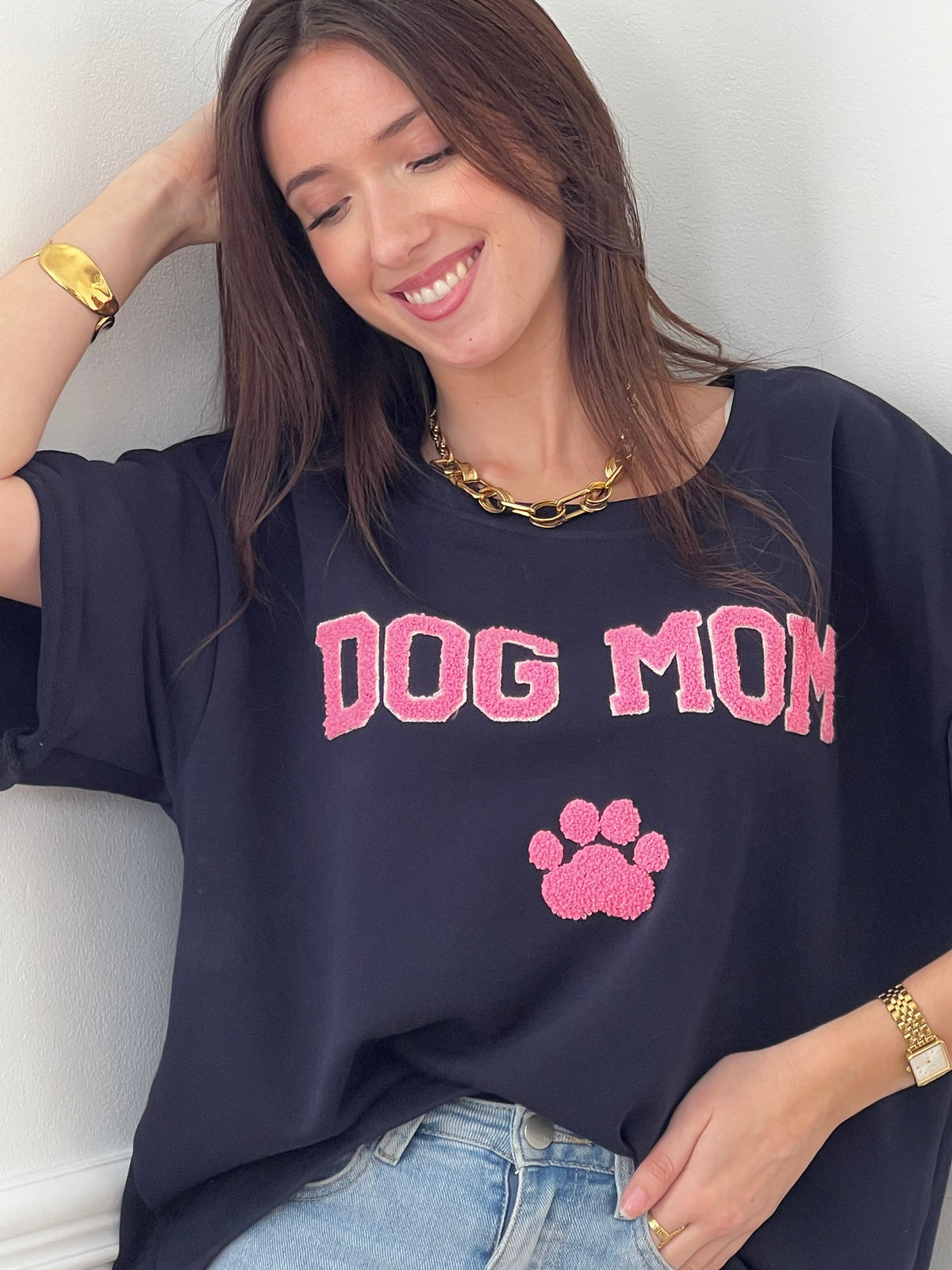 Craquez pour ce tee-shirt style sweat femme, confortable et tendance. Doté de manches courtes et d’un col rond, il est confectionné en 100 % coton pour un confort optimal. Son inscription “Dog mom” en rose et écru avec une patte de chien apporte une touche fun et originale. Ses couleurs bleu, rose et écru en font une pièce facile à porter au quotidien.