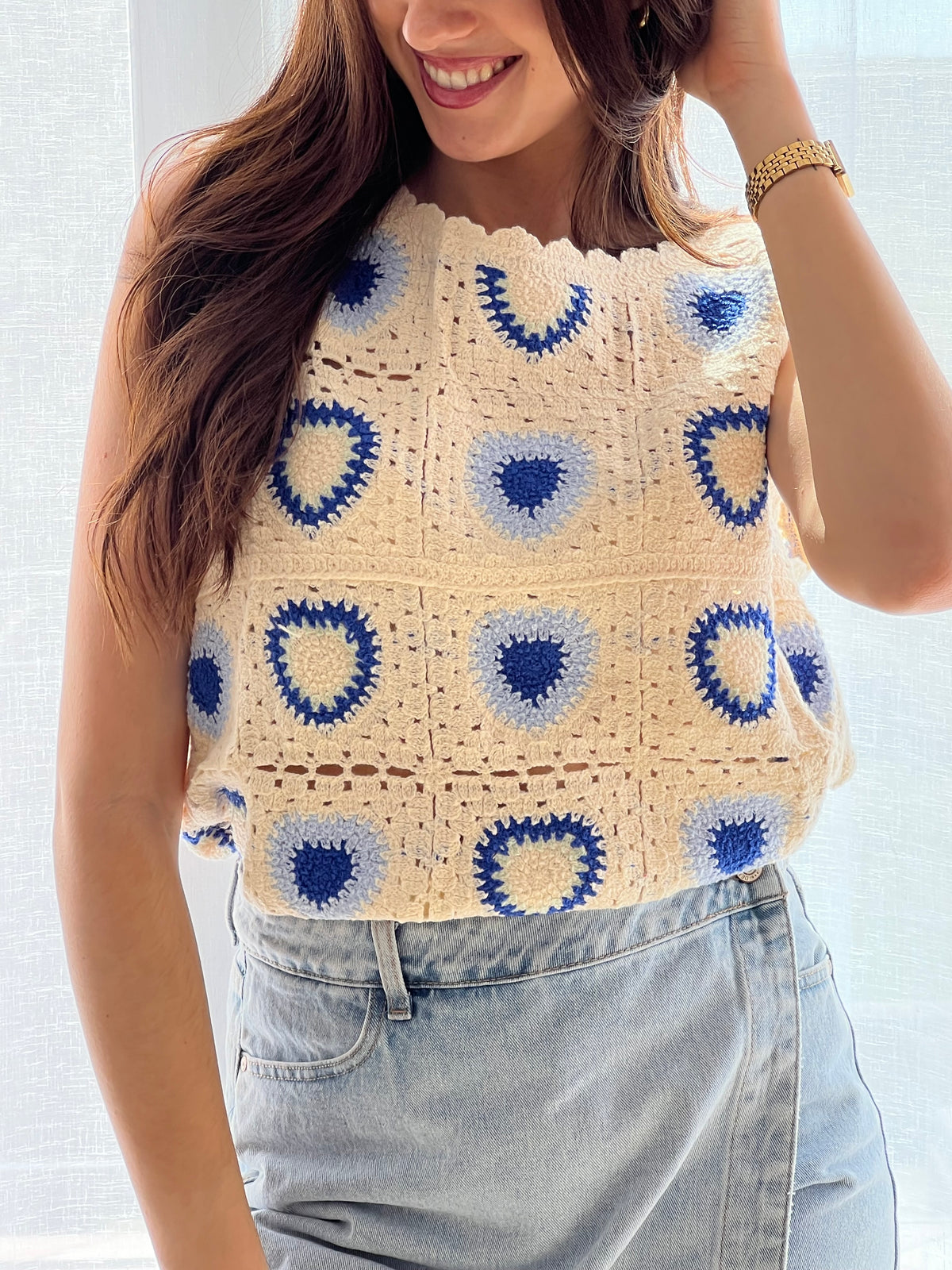 Top en crochet bleu femme au style bohème et tendance, idéal pour les beaux jours. Sans manches avec un col rond et une attache bouton au dos, il allie confort et élégance. Ses finitions festonnées au col, aux manches et au bas apportent une touche délicate et raffinée. Ses nuances de beige, bleu clair et bleu foncé avec motifs en font une pièce unique et facile à assortir.