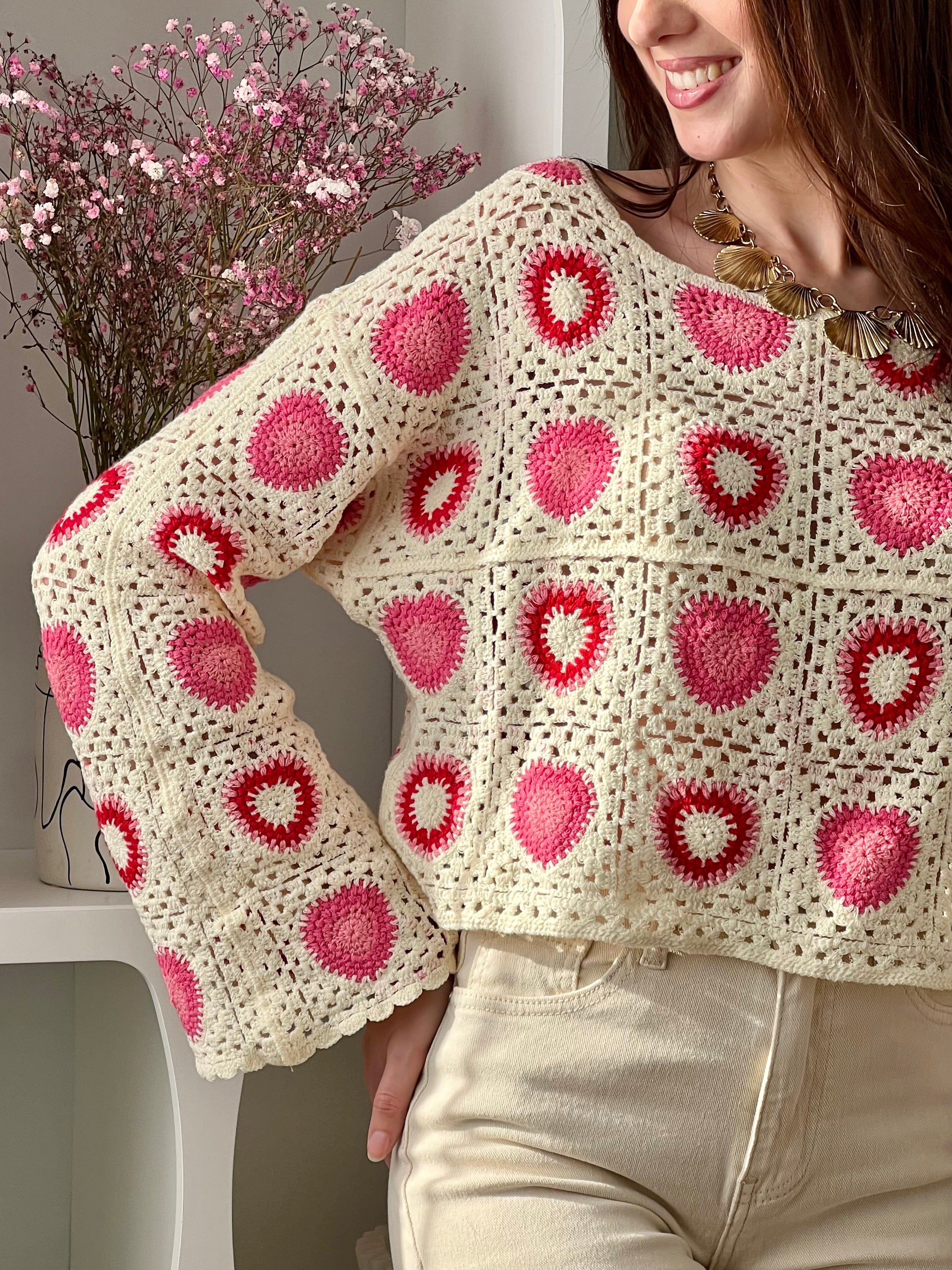 Craquez pour ce top beige en crochet femme, délicat et tendance. Doté de manches longues et d’un col rond, il se distingue par son crochet ajouré qui apporte légèreté et féminité. Ses motifs cœurs rose et rouge ajoutent une touche romantique et originale à votre tenue.