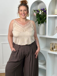 Sublimez votre allure avec ce top beige, orné d'une délicate dentelle sur son col V et doté de bretelles réglables pour un ajustement parfait. Élégance et féminité au rendez-vous.&nbsp;