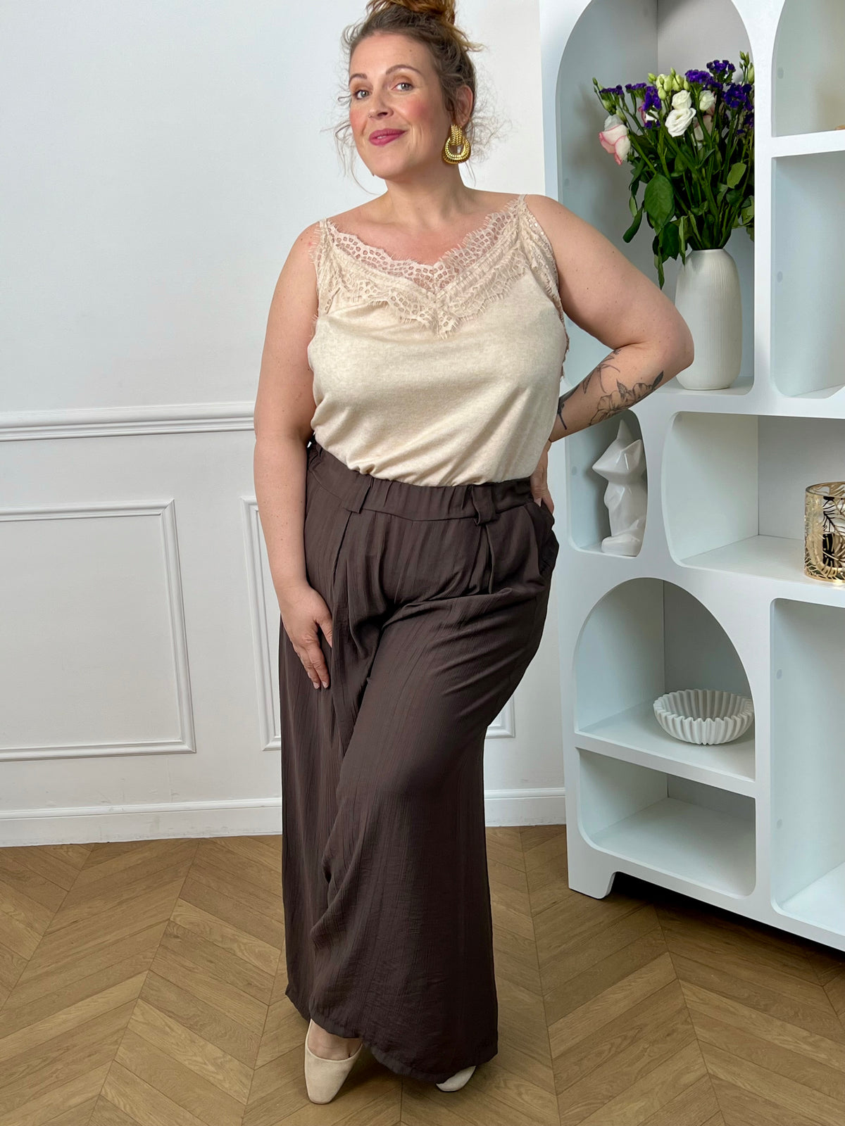 Sublimez votre allure avec ce top beige, orné d'une délicate dentelle sur son col V et doté de bretelles réglables pour un ajustement parfait. Élégance et féminité au rendez-vous.&nbsp;