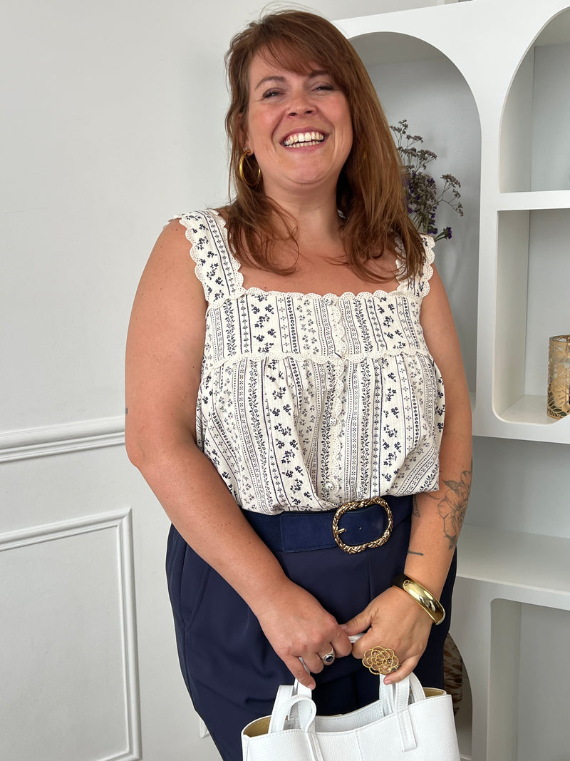 Craquez pour ce top à motifs grande taille au charme bohème et féminin. Confectionné en 100% coton, il offre une sensation de légèreté et de confort idéale pour les beaux jours. Son col carré met délicatement le décolleté en valeur, tandis que les broderies sur le haut et les bretelles apportent une touche raffinée. Les boutons factices sur toute la longueur et les motifs bleu marine sur fond écru complètent son style élégant et intemporel. Une pièce facile à associer pour un look chic et décontracté.