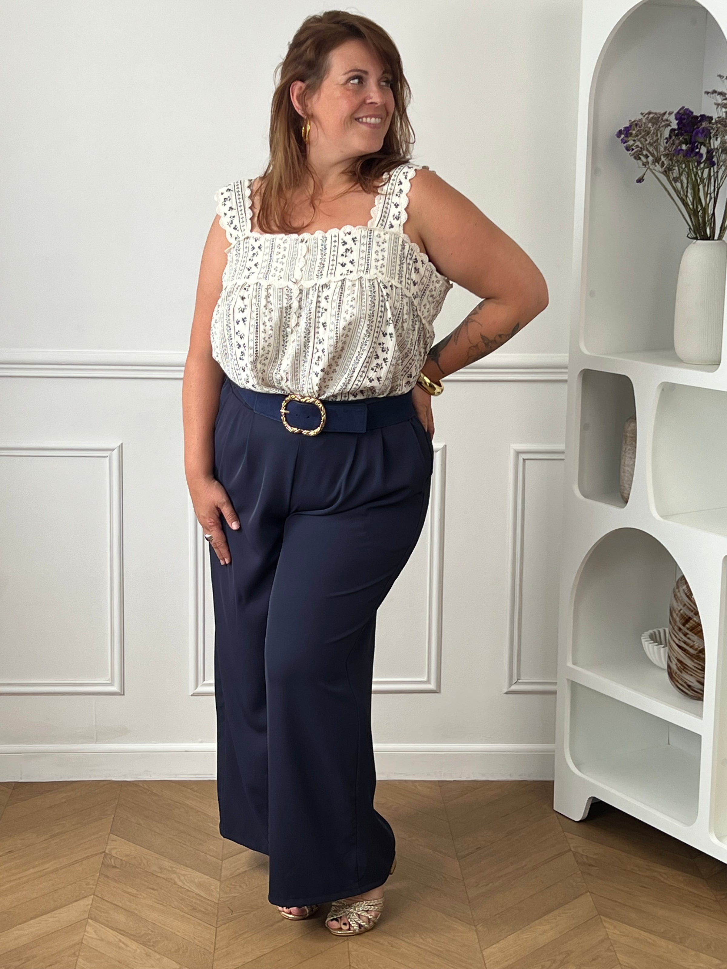 Craquez pour ce top à motifs grande taille au charme bohème et féminin. Confectionné en 100% coton, il offre une sensation de légèreté et de confort idéale pour les beaux jours. Son col carré met délicatement le décolleté en valeur, tandis que les broderies sur le haut et les bretelles apportent une touche raffinée. Les boutons factices sur toute la longueur et les motifs bleu marine sur fond écru complètent son style élégant et intemporel. Une pièce facile à associer pour un look chic et décontracté.