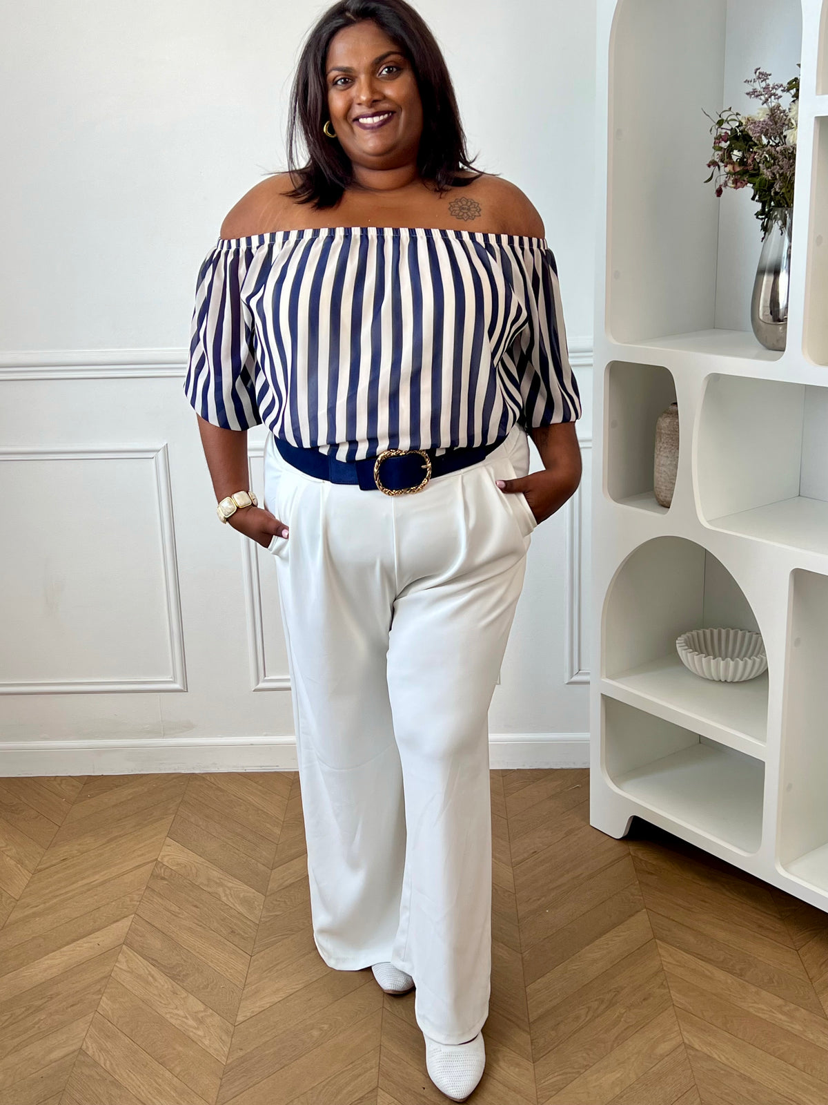 Apportez une touche d’élégance à votre dressing avec cette blouse grande taille à col bateau. Légère et fluide, elle offre un tombé féminin et confortable, idéal pour le quotidien. Ses manches courtes amples et son col bateau élastique assurent une allure décontractée et raffinée, tandis que les rayures verticales bleu marine et écru allongent visuellement la silhouette. Doublée sur le corps pour plus de confort et légèrement transparente aux manches, cette blouse est parfaite pour un look chic et intempore