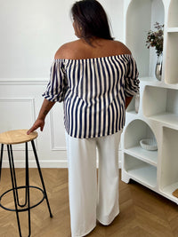 Apportez une touche d’élégance à votre dressing avec cette blouse grande taille à col bateau. Légère et fluide, elle offre un tombé féminin et confortable, idéal pour le quotidien. Ses manches courtes amples et son col bateau élastique assurent une allure décontractée et raffinée, tandis que les rayures verticales bleu marine et écru allongent visuellement la silhouette. Doublée sur le corps pour plus de confort et légèrement transparente aux manches, cette blouse est parfaite pour un look chic et intempore